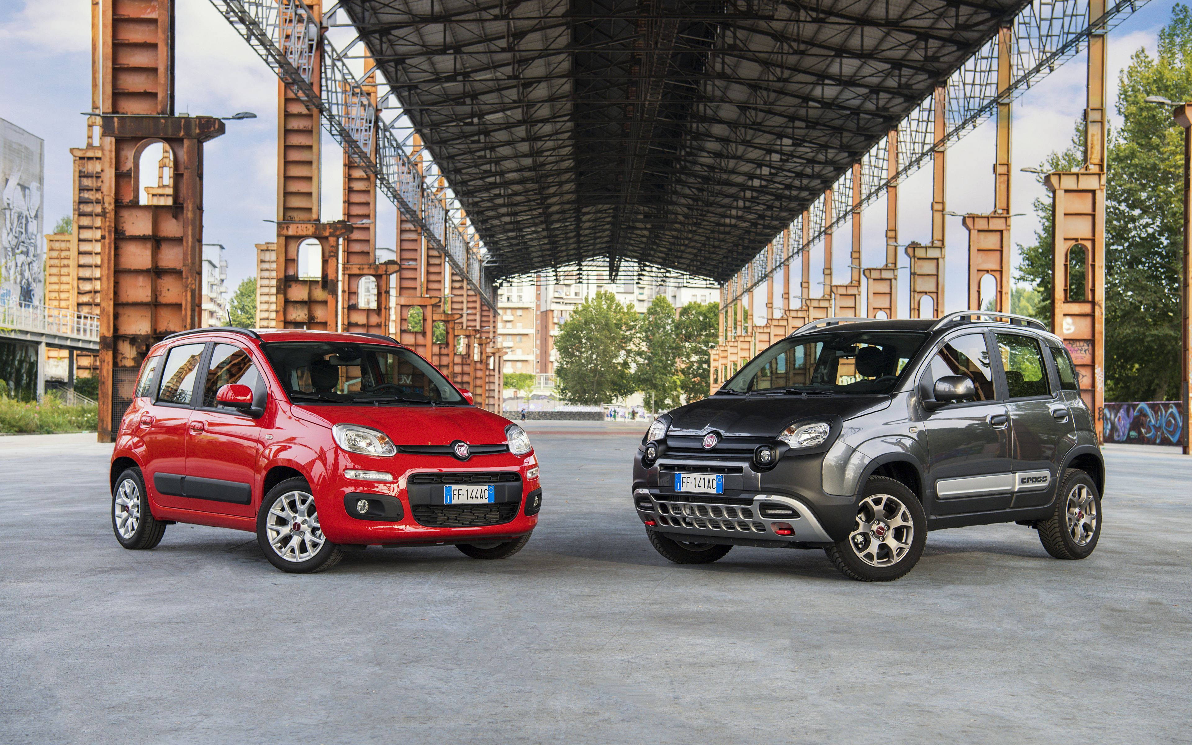 Fiat 桌布 壁紙 — 兩輛紅色和灰色的Fiat Panda汽車停放在一個生鏽的工業金屬結構下，背景有塗鴉和樹木。