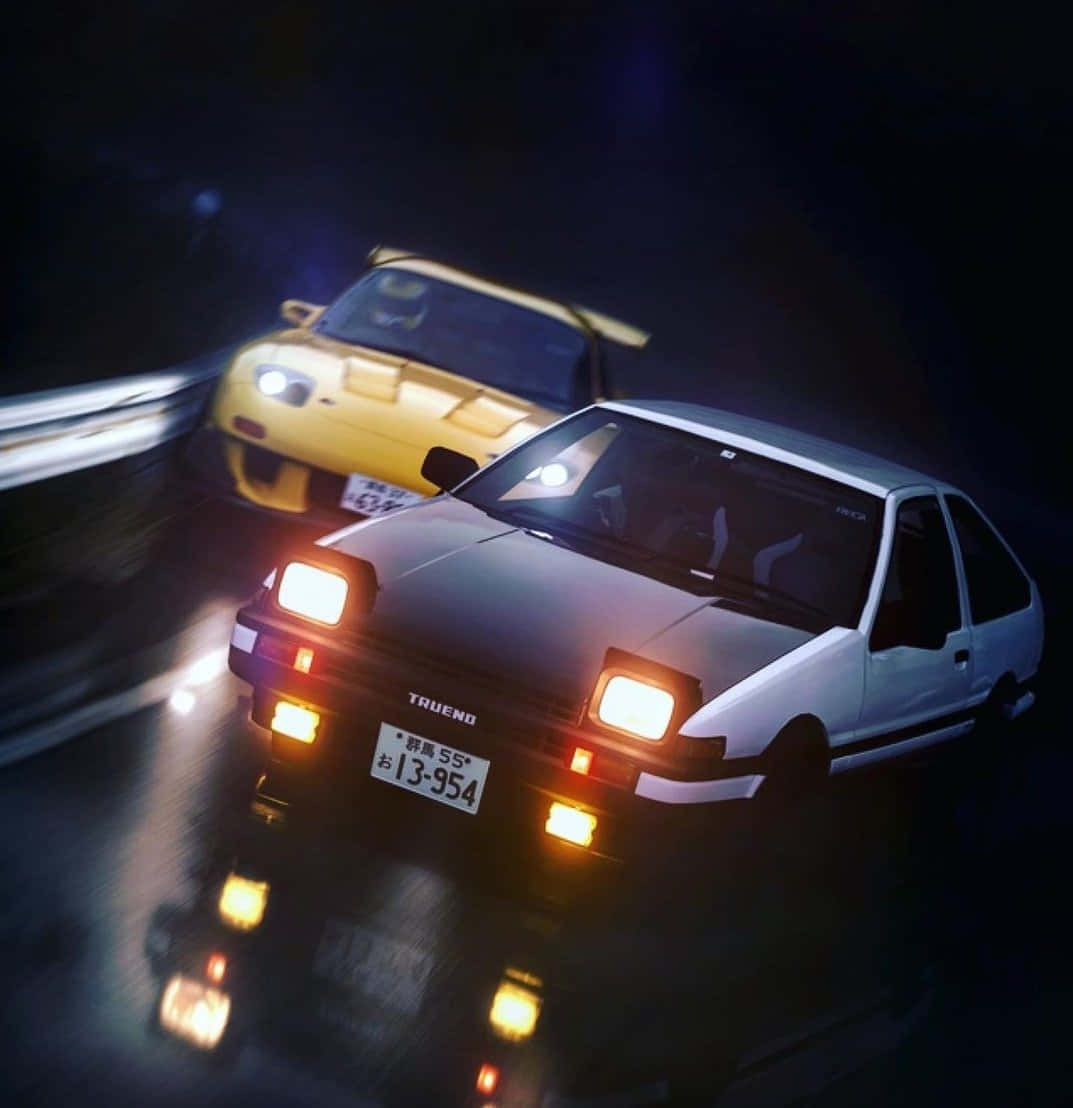 桌布 壁紙 — 兩輛經典日本跑車在夜間比賽，發光的車頭燈在潮濕的道路上劃破黑暗。