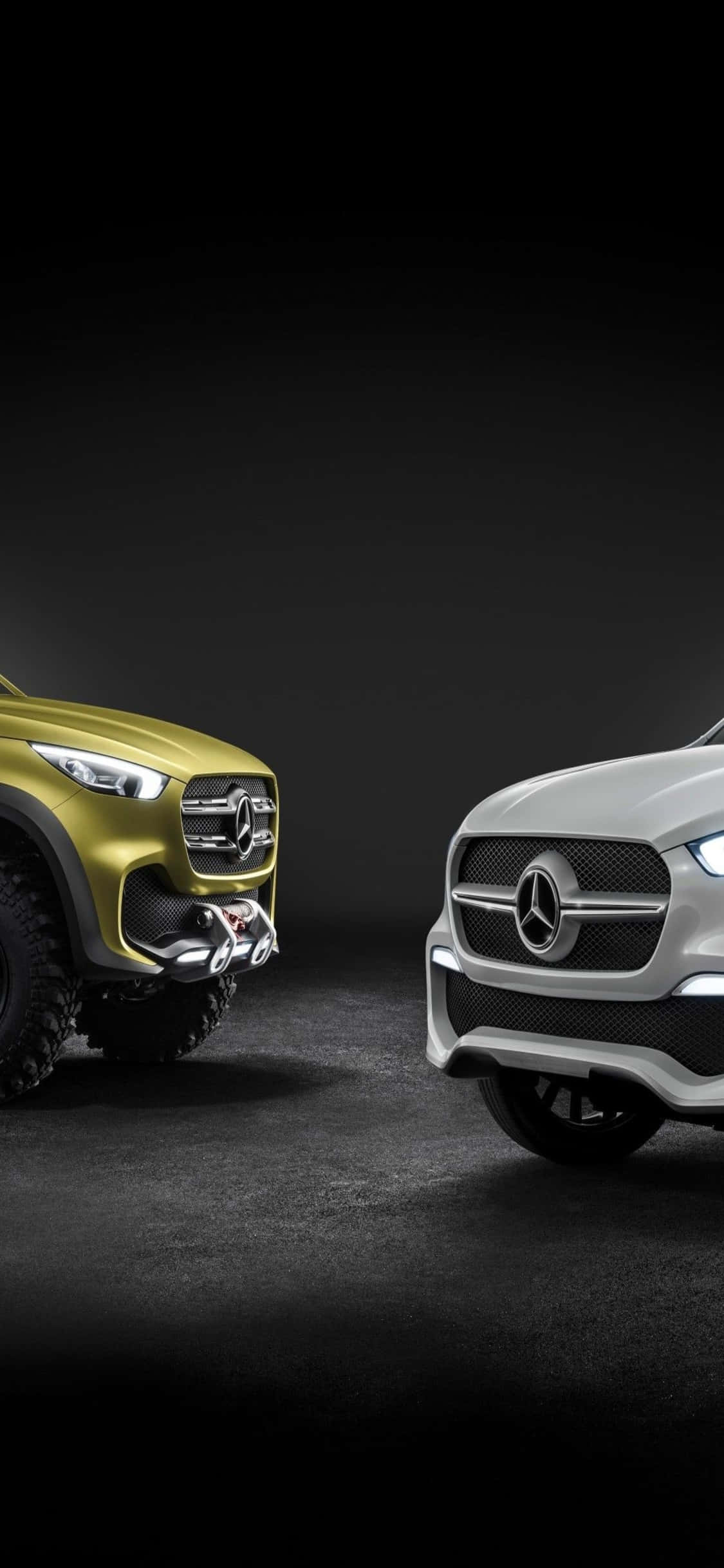 Mercedes 桌布 壁紙 — 兩輛賓士SUV，一金一銀，在昏暗的攝影棚中以戲劇性的燈光對峙。