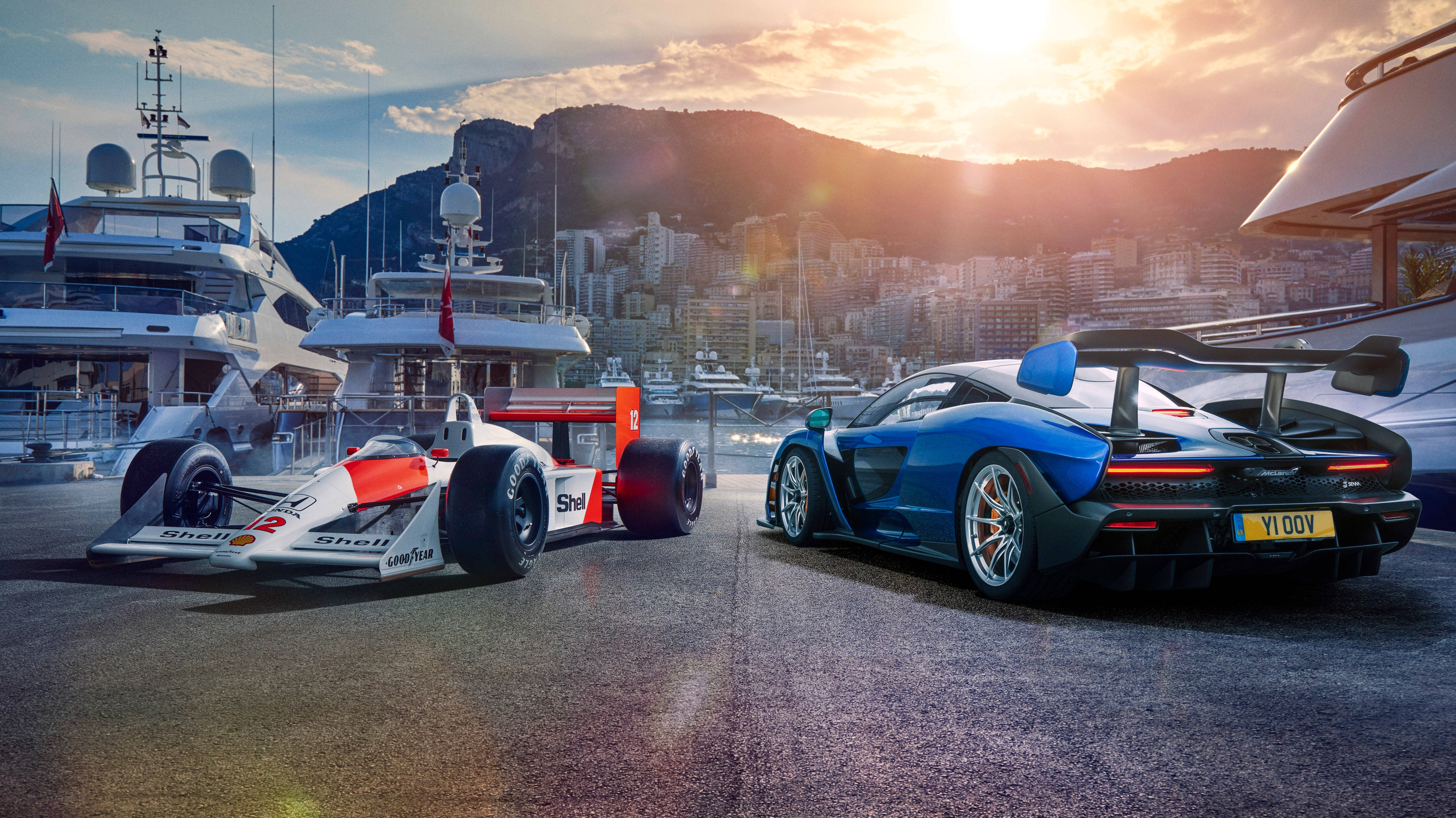 F1 桌布 壁紙 — 兩輛高性能賽車，一輛經典一級方程式和一輛現代超級跑車，在日落時停泊在豪華遊艇碼頭。