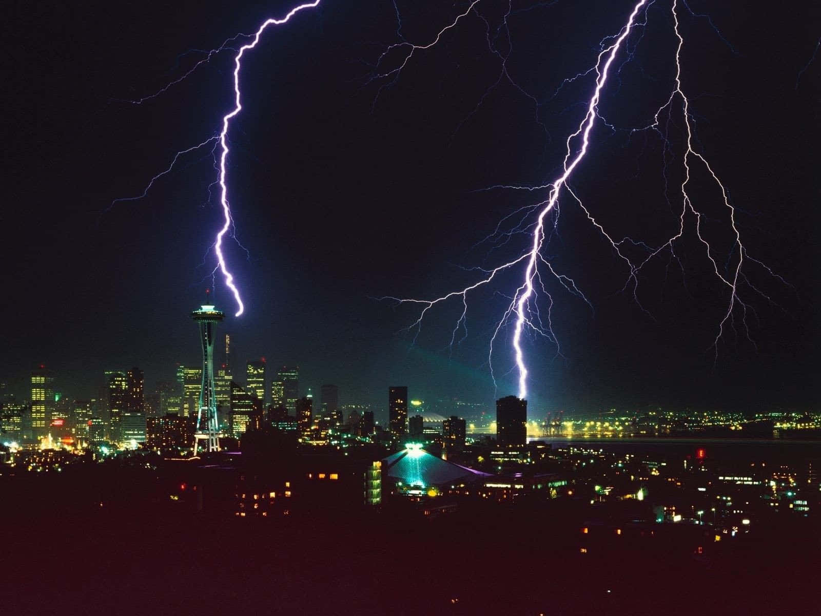 Washington 桌布 壁紙 — 兩道巨大的閃電照亮了黑暗的夜空，下方是燈火通明的城市景觀，其中可見太空針塔。