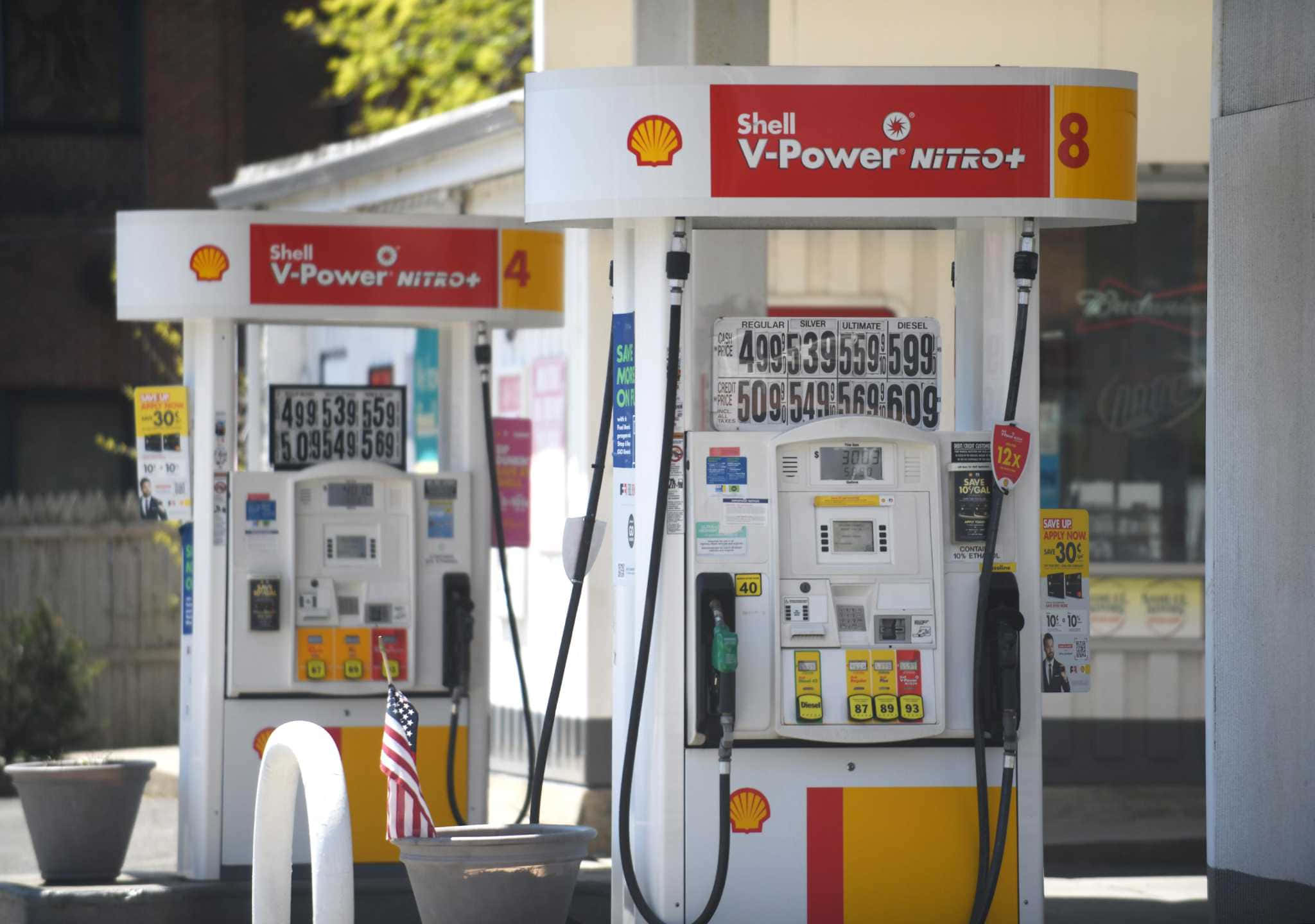 Gas Station 桌布 壁紙 — 兩部Shell V-Power Nitro+油泵在明亮日光下並排而立，顯示價格及可見美國國旗。