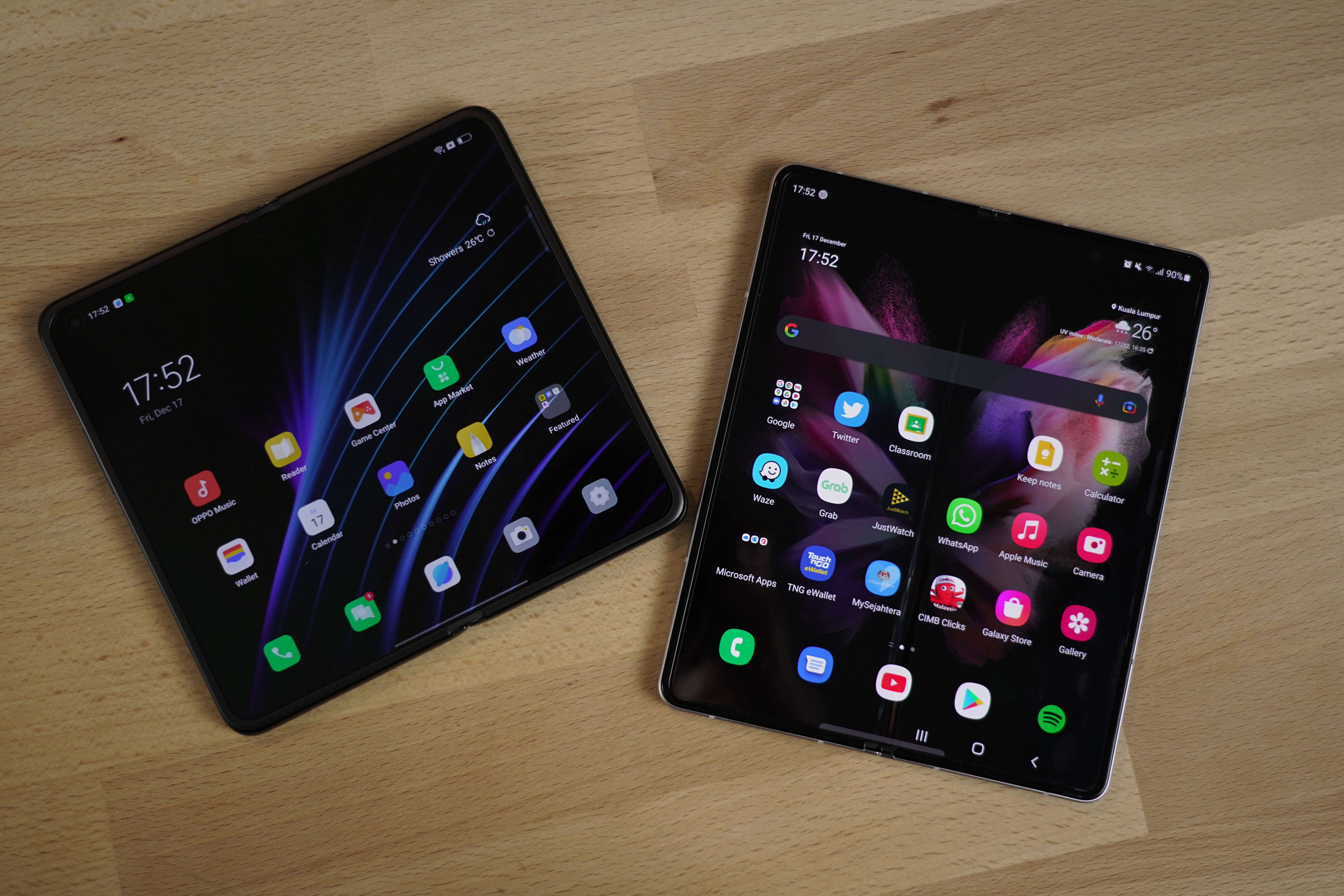 oppo 桌布 壁紙 — 兩部可摺疊智慧型手機，螢幕色彩鮮豔顯示應用程式圖示，放置在淺色木質表面上。