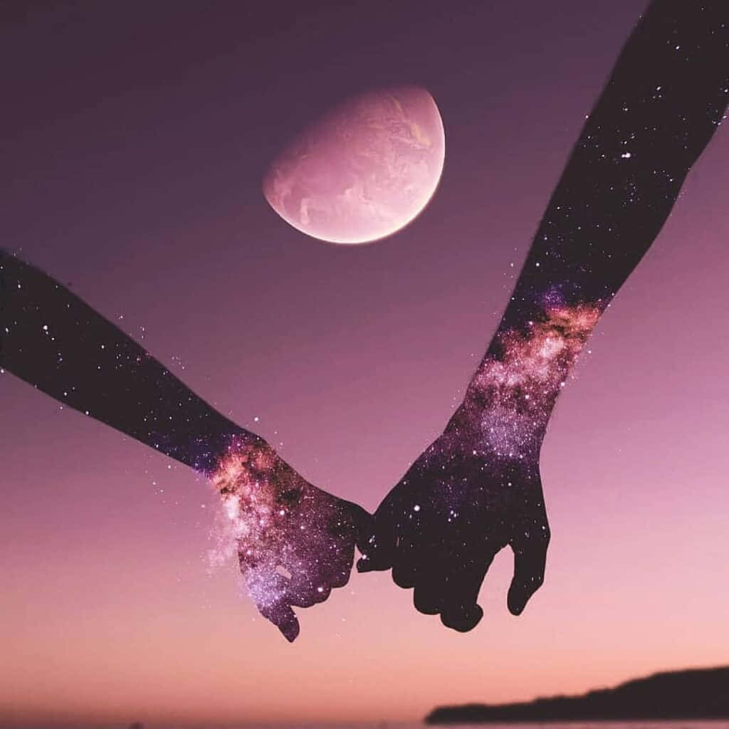 Aesthetic Cute Profile 桌布 壁紙 — 兩隻剪影手在暮色天空下互相緊握，天空中有發光行星，手臂內有宇宙圖案旋轉。