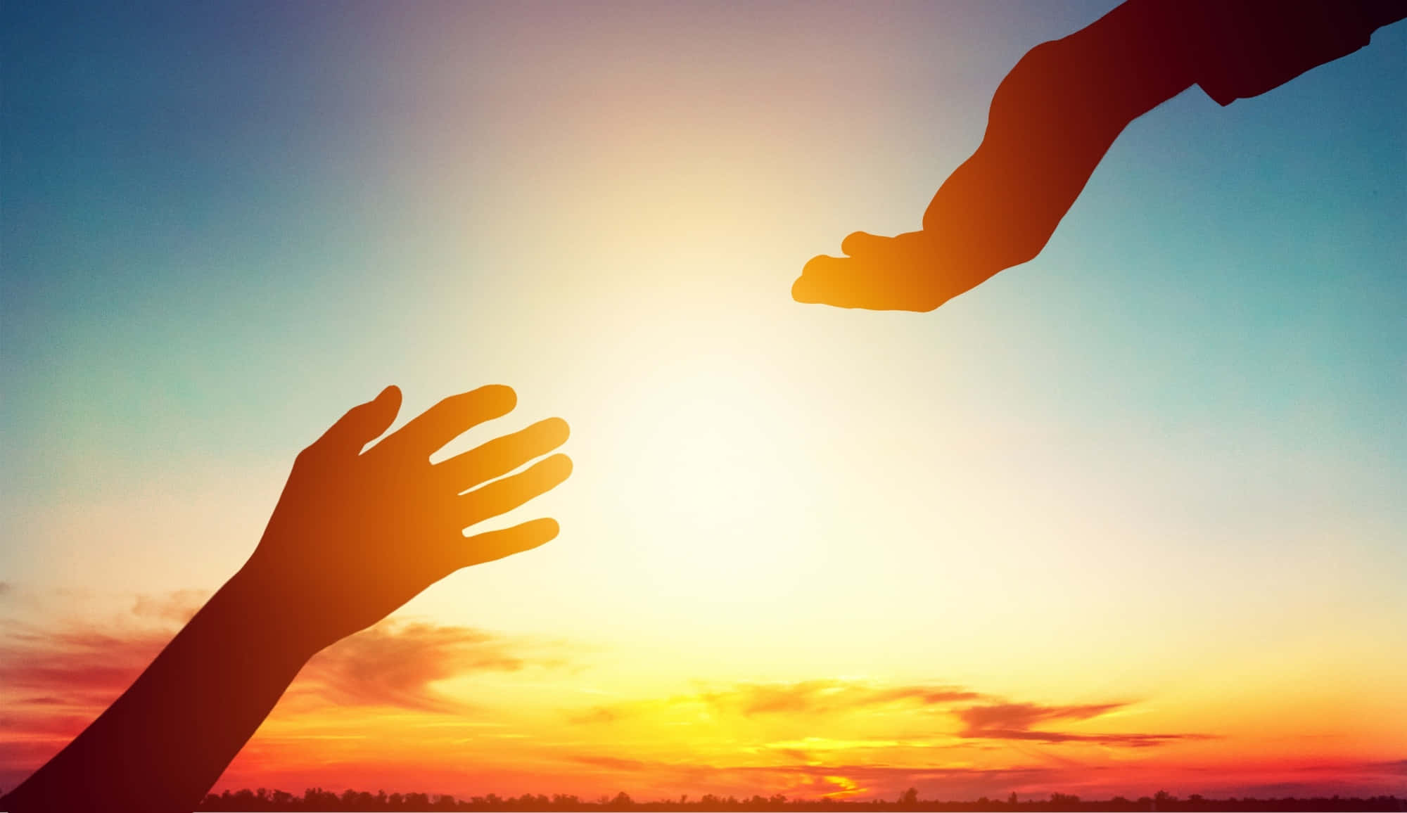 Forgiving 桌布 壁紙 — 兩隻剪影的手在溫暖的橙色和藍色漸變的鮮豔日落天空下互相伸向對方。