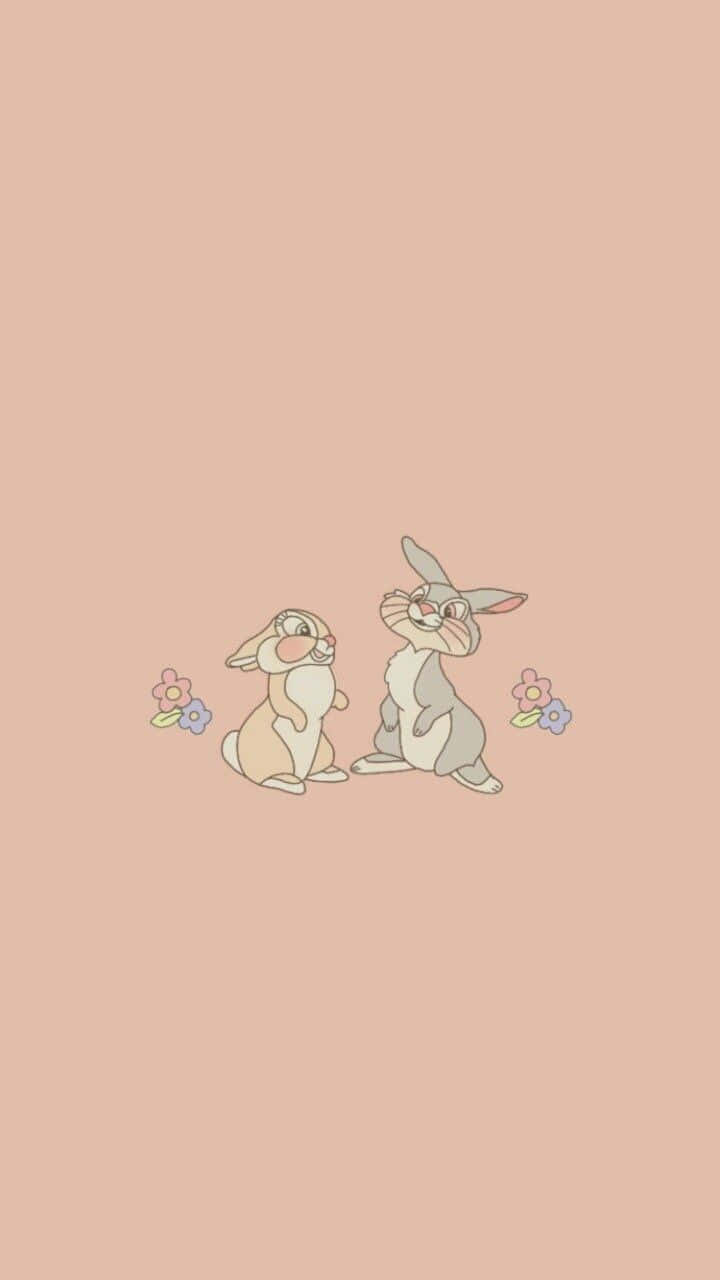 Miss Rabbit 桌布 壁紙 — 兩隻可愛的卡通兔子面對面坐在柔軟的桃色背景上，旁邊有細小的花朵。