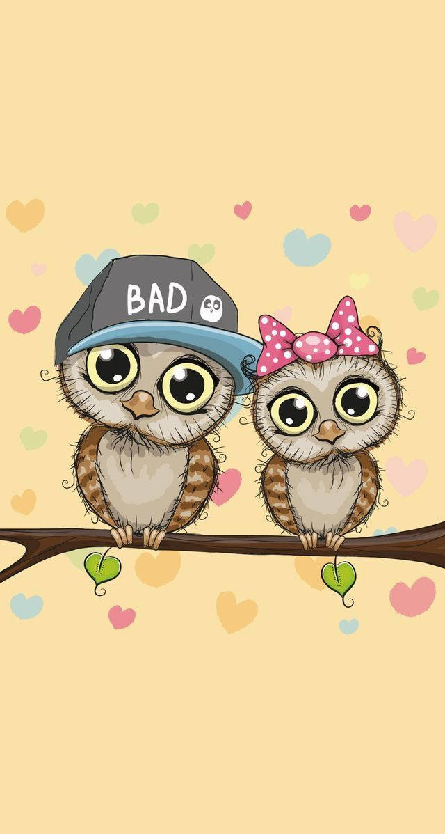 birds 桌布 壁紙 — 兩隻可愛的卡通貓頭鷹，有大眼睛，棲息在一根樹枝上，周圍是色彩繽紛的心形，背景是柔和的黃色。