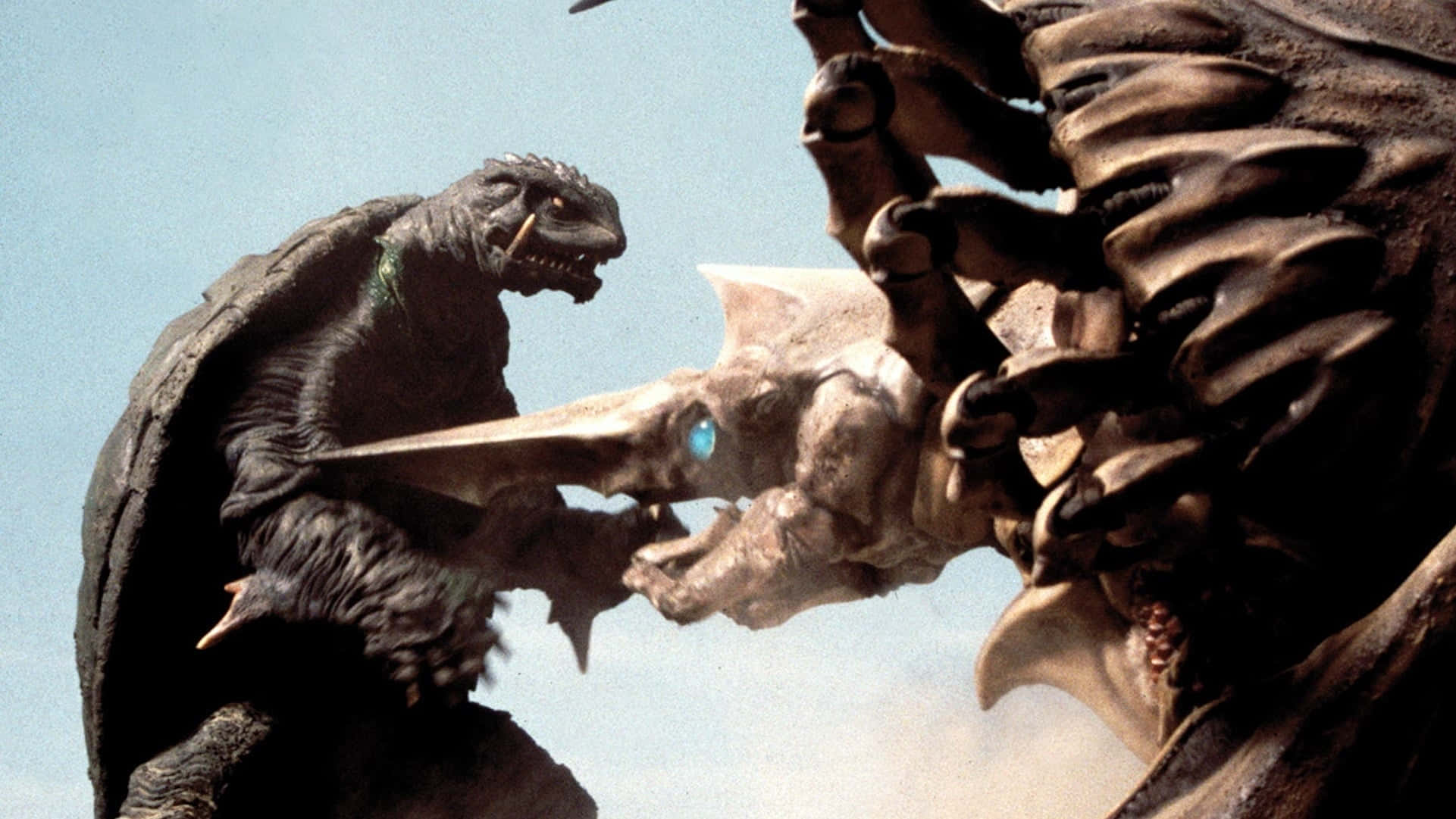 Gamera 桌布 壁紙 — 兩隻巨型怪物在晴朗藍天下激烈戰鬥，其中一隻揮舞著發光的劍。