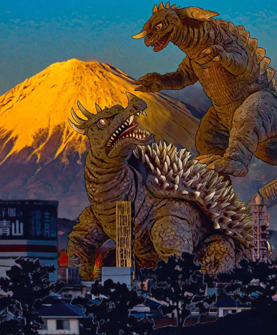 Godzilla Vs Anguirus 桌布 壁紙 — 兩隻巨型怪獸在城市天際線上碰撞，背景中的富士山閃耀著金色光芒。