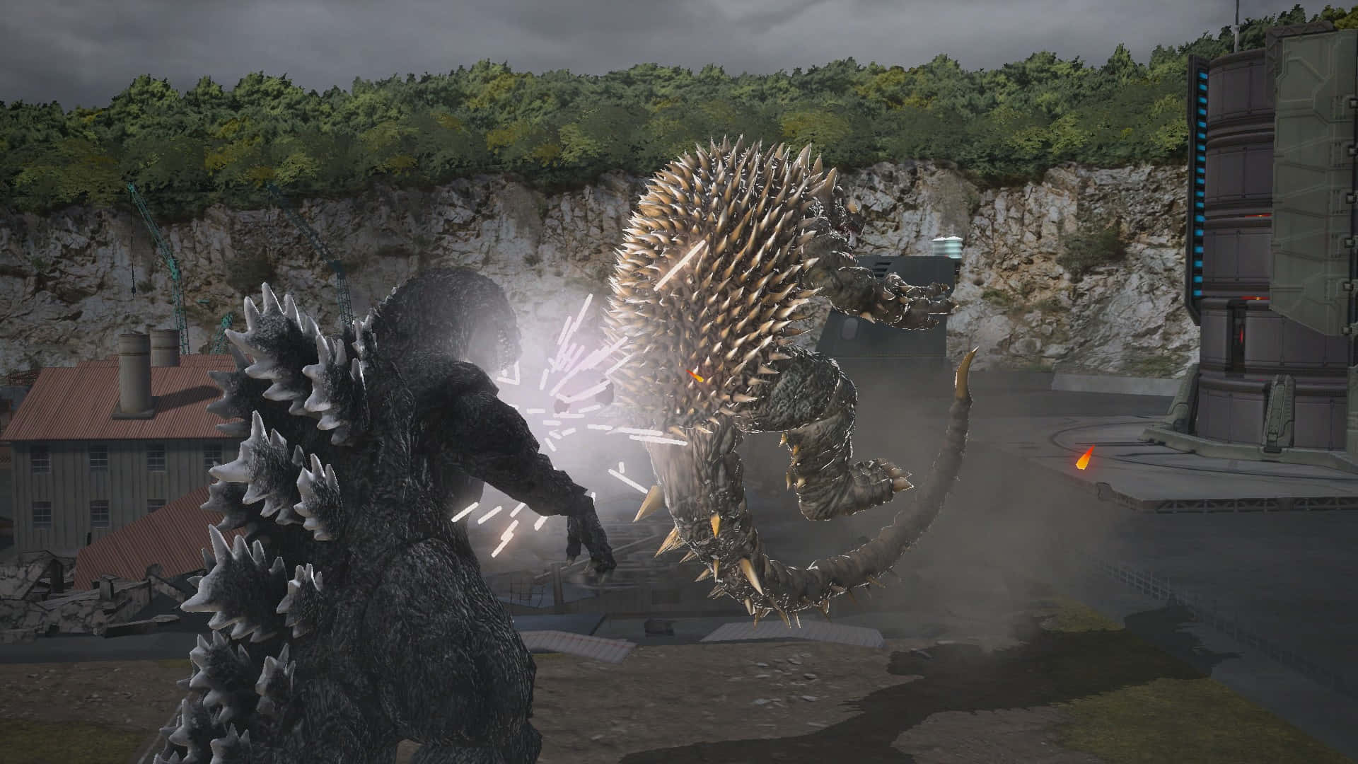 Godzilla Vs Anguirus 桌布 壁紙 — 兩隻巨型怪獸在岩石工業區碰撞，火花四濺，背景有建築物。