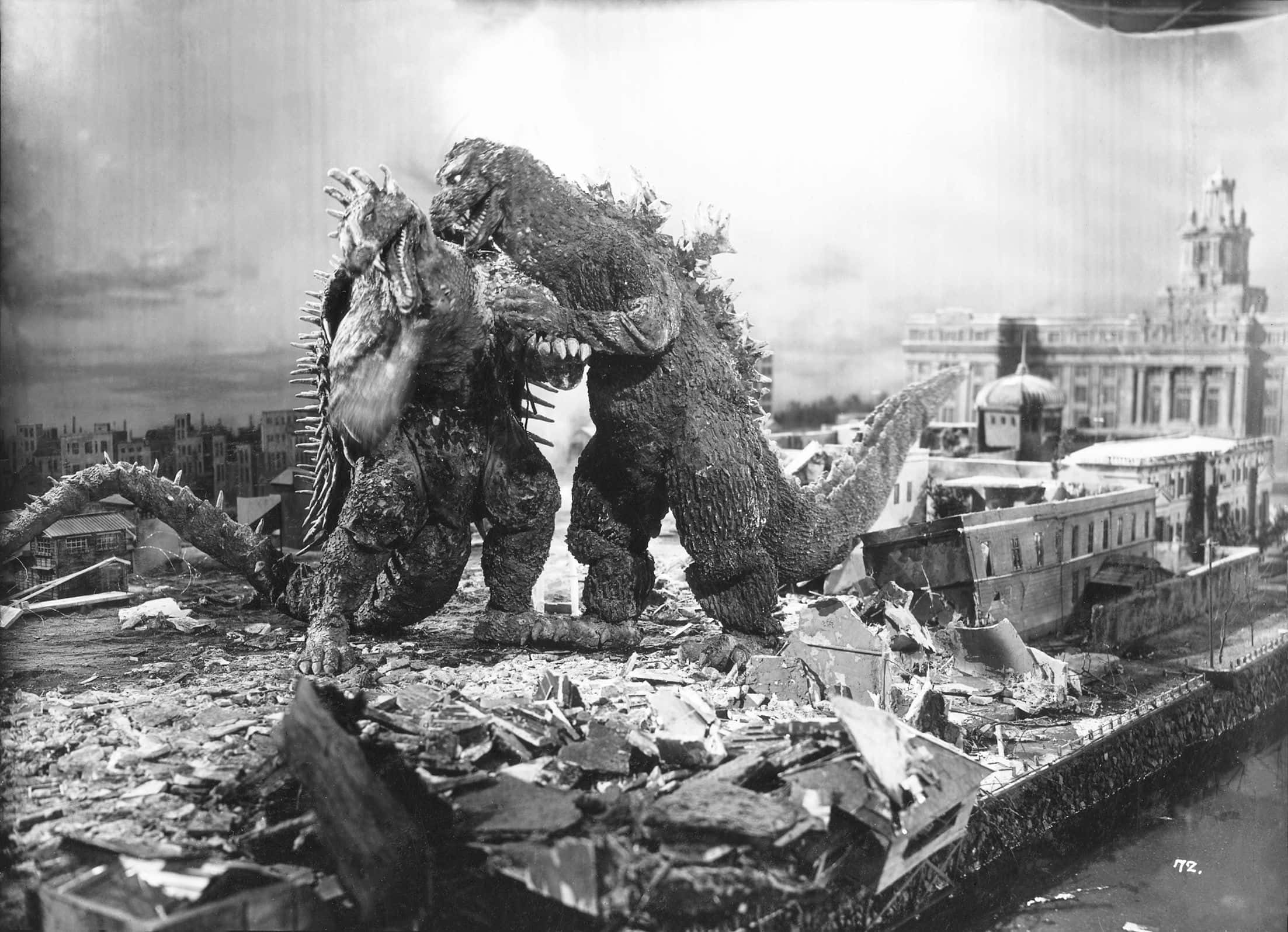 Godzilla 1954 桌布 壁紙 — 兩隻巨型怪獸在經典黑白電影劇照中，在被摧毀的城市景觀中的瓦礫中碰撞。