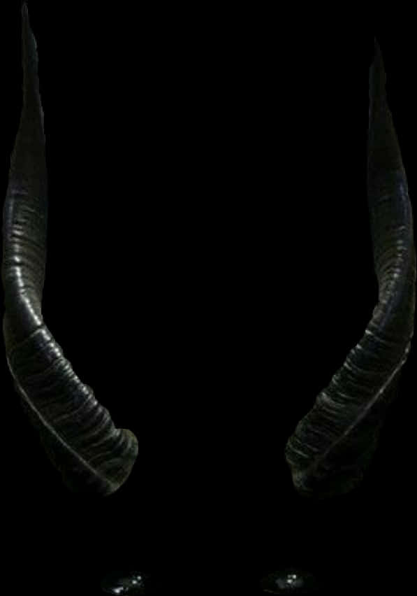 Devil Horn 桌布 壁紙 — 兩隻帶有紋理脊狀的深色彎曲角在純黑色背景上隱約發光。