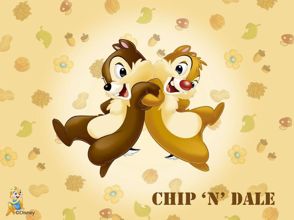 Chip 桌布 壁紙 — 兩隻快樂的卡通花栗鼠在溫暖的黃色背景上歡快地跳躍，背景散落著秋葉和橡子。