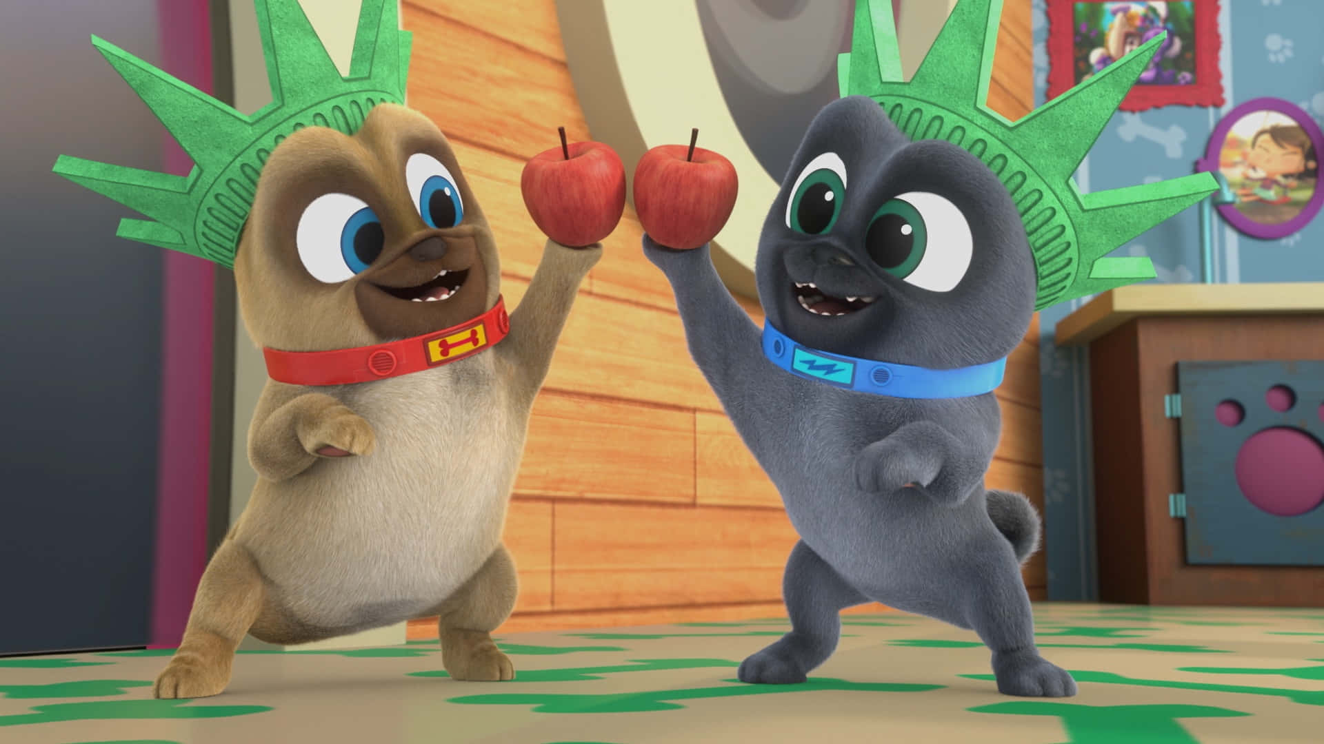Puppy Dog Pals 桌布 壁紙 — 兩隻戴著自由女神像帽子的開心動畫小狗角色，在色彩繽紛的室內環境中愉快地舉起紅蘋果。