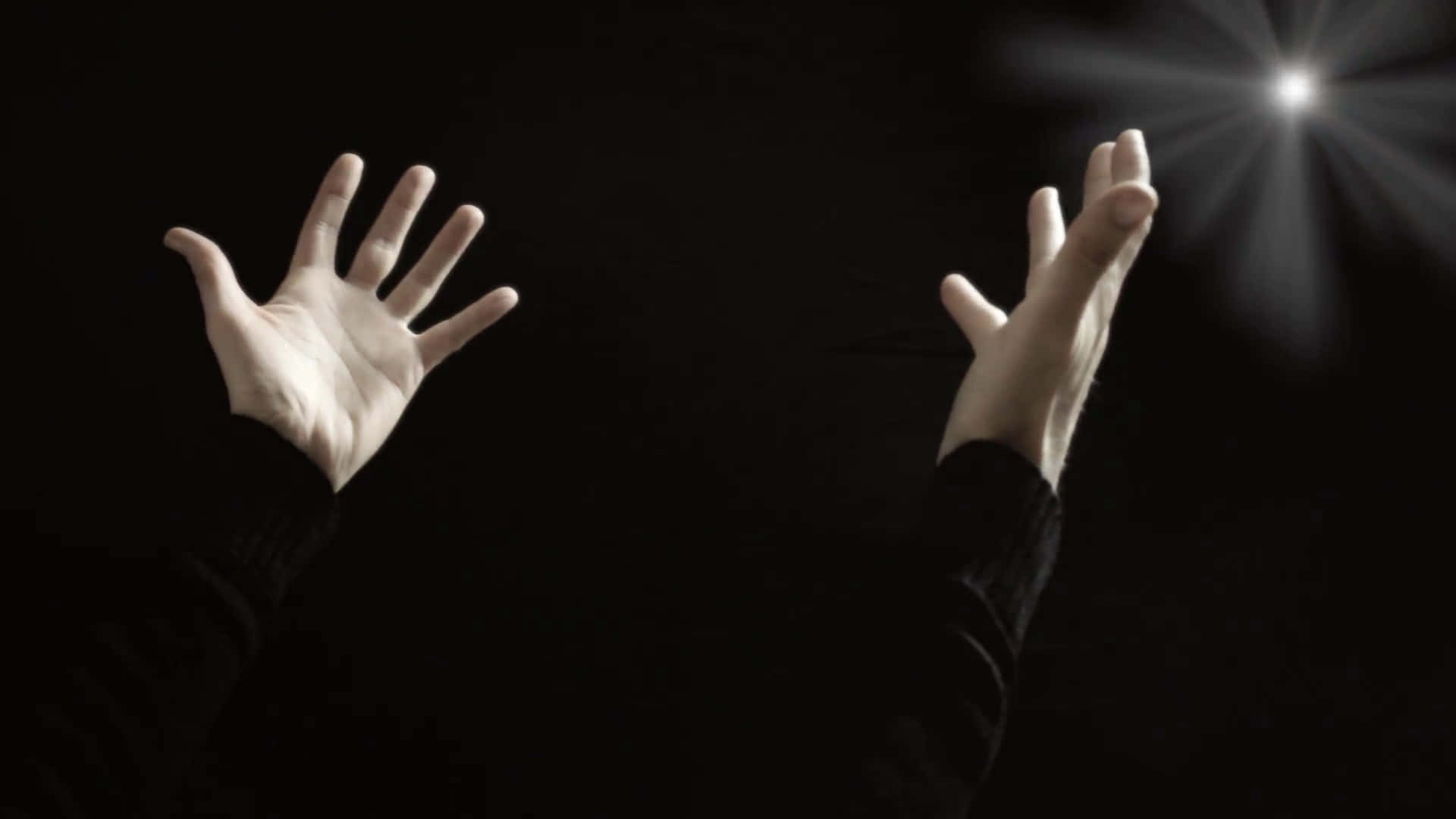 hands 桌布 壁紙 — 兩隻手向上伸向深黑色背景上的明亮星光爆發。