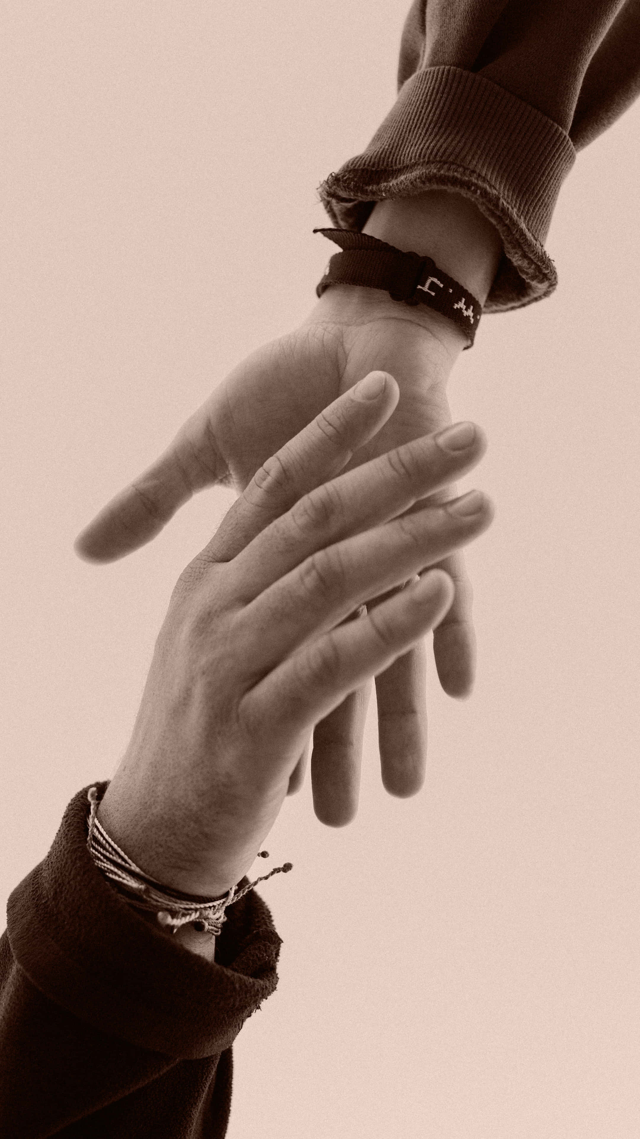 Friendship 桌布 壁紙 — 兩隻手在溫暖的懷舊色調中溫柔觸碰，捕捉了細膩質感和柔和光線下的溫馨時刻。