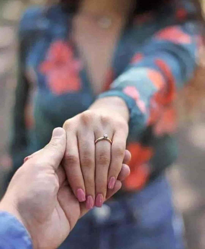 Whatsapp Dp 桌布 壁紙 — 兩隻手在溫柔的時刻緊握在一起，其中一隻戴著鑽石訂婚戒指，指甲塗有粉紅色指甲油。