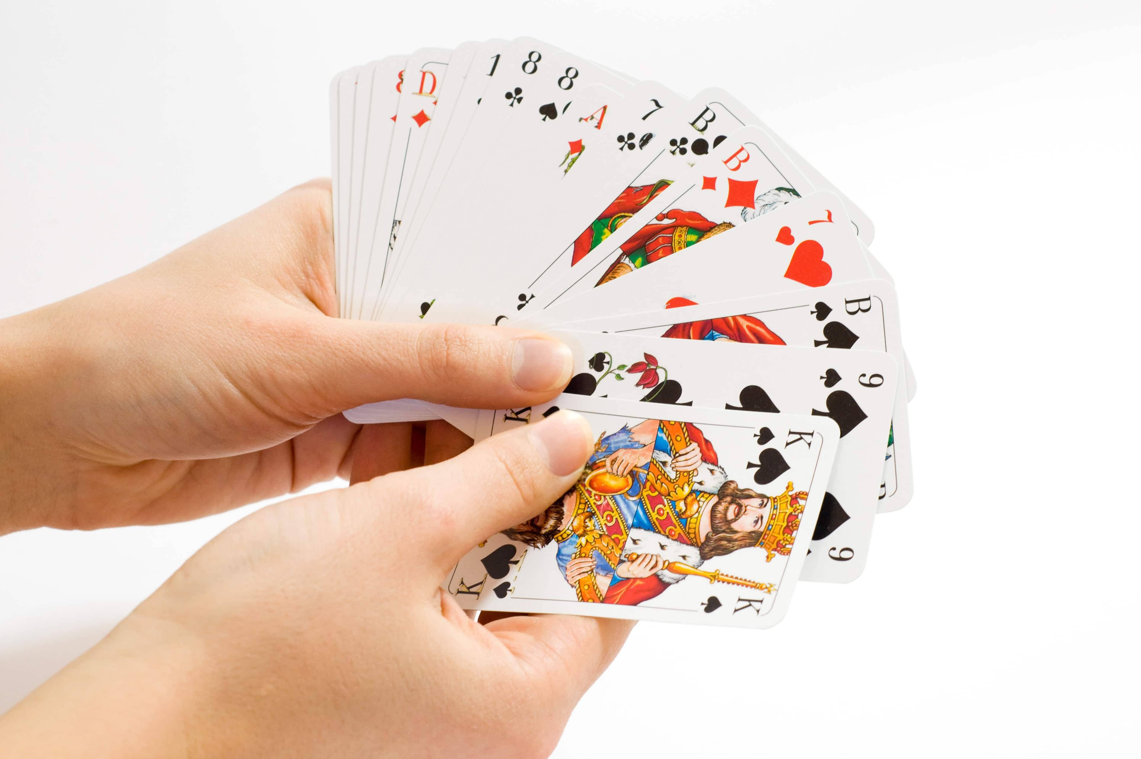 Playing Cards 桌布 壁紙 — 兩隻手在純白背景上展開一把色彩繽紛的撲克牌扇。