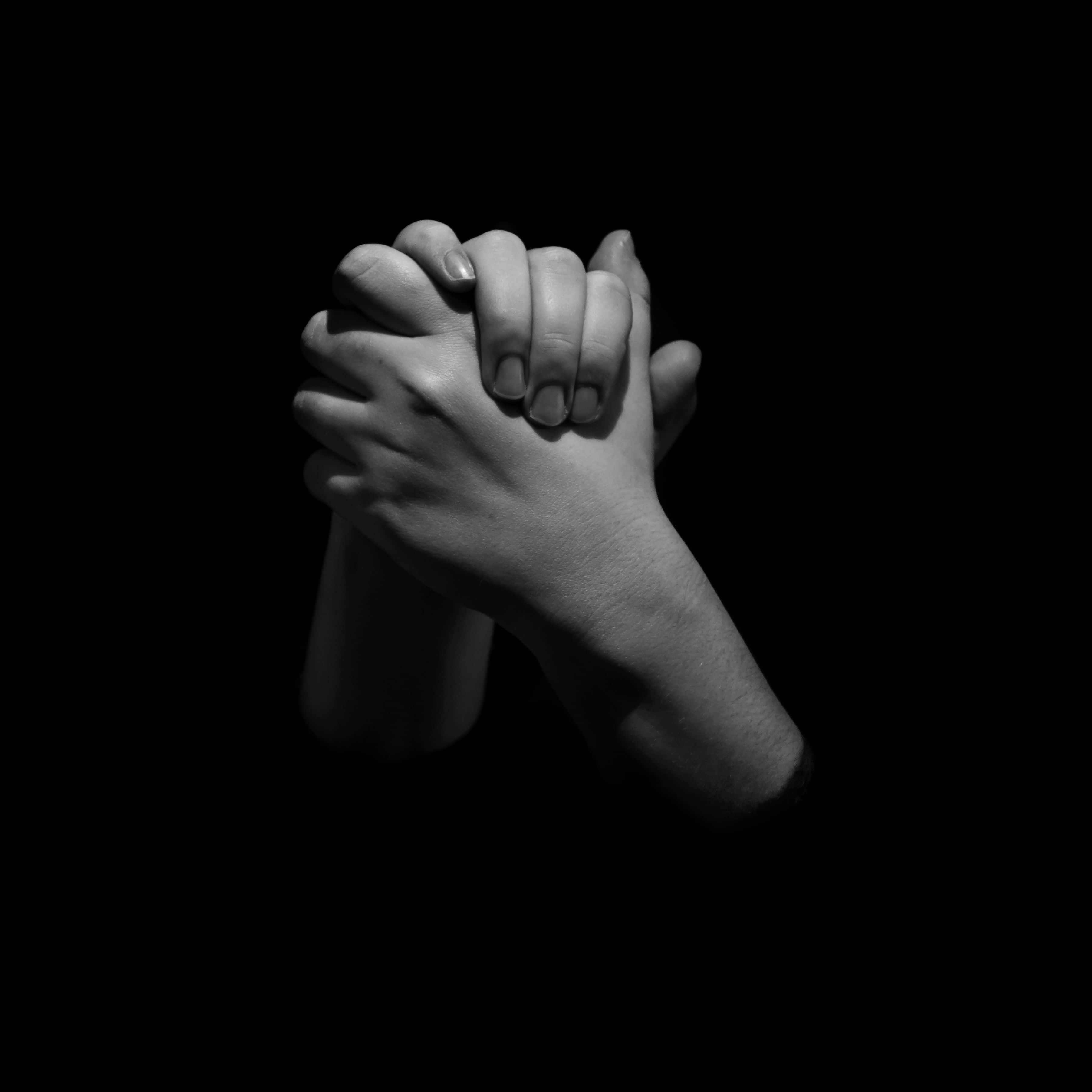Praying 桌布 壁紙 — 兩隻手在純黑色背景下的單色鏡頭中緊緊握在一起。