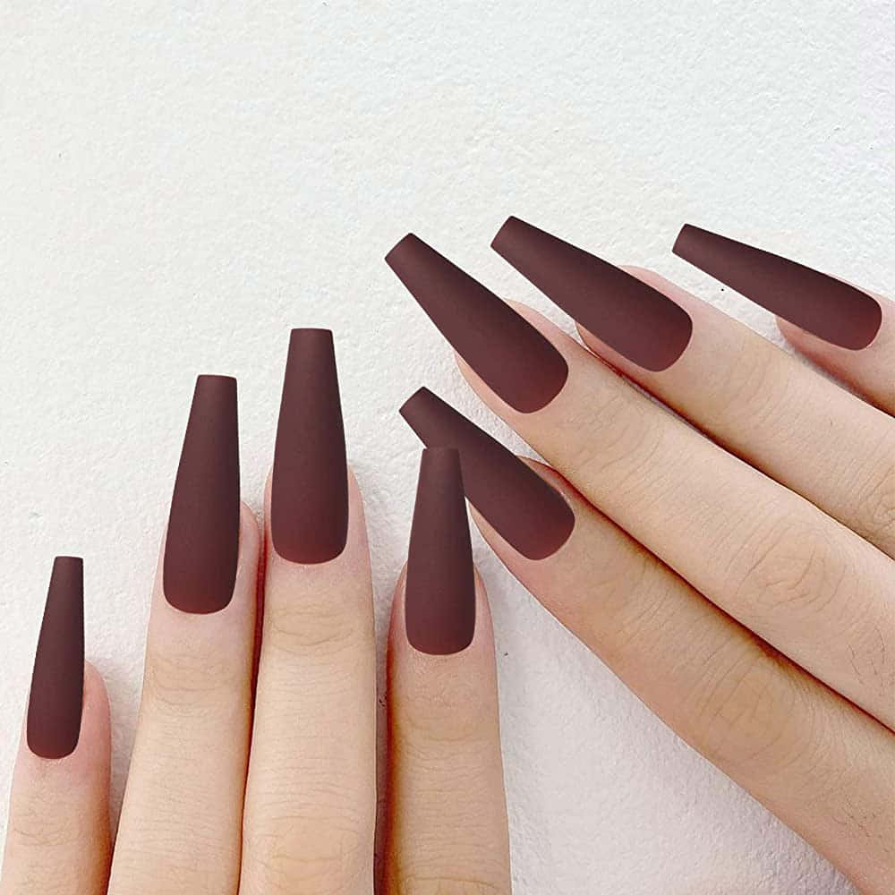 Fake Nail 桌布 壁紙 — 兩隻手展示長啞光深棕色棺材形指甲，背景為柔軟白色紋理。