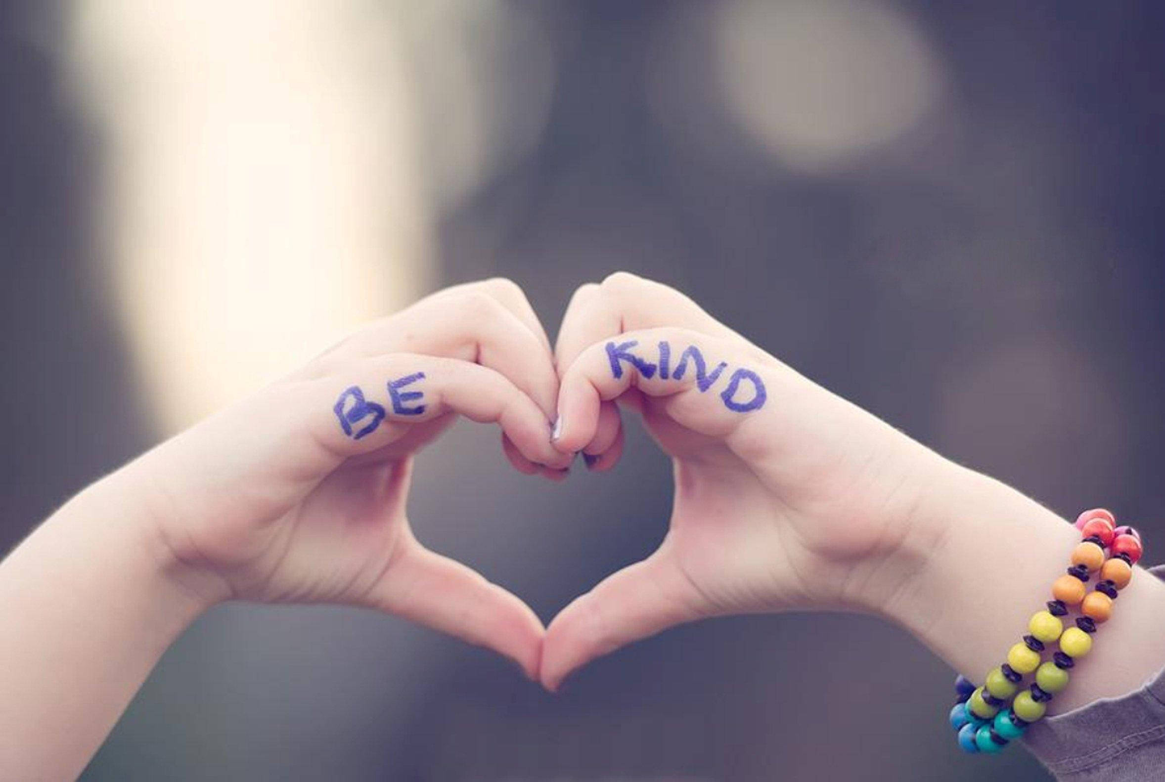 愛心 桌布 壁紙 — 兩隻手形成心形，手掌上寫有「BE KIND」，背景柔和模糊。