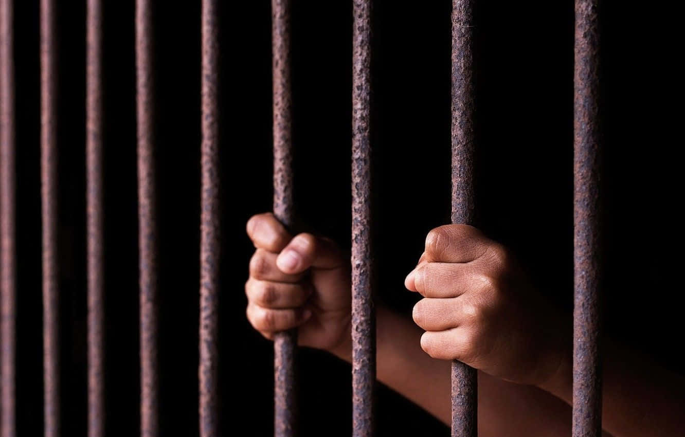 Prison Cell 桌布 壁紙 — 兩隻手抓住生鏽的金屬棒，背景漆黑，傳達出禁錮與絕望。