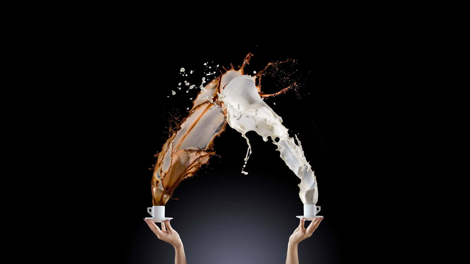 Splash 桌布 壁紙 — 兩隻手拿著咖啡杯和牛奶杯，液體在黑色背景前戲劇性地在空中飛濺。