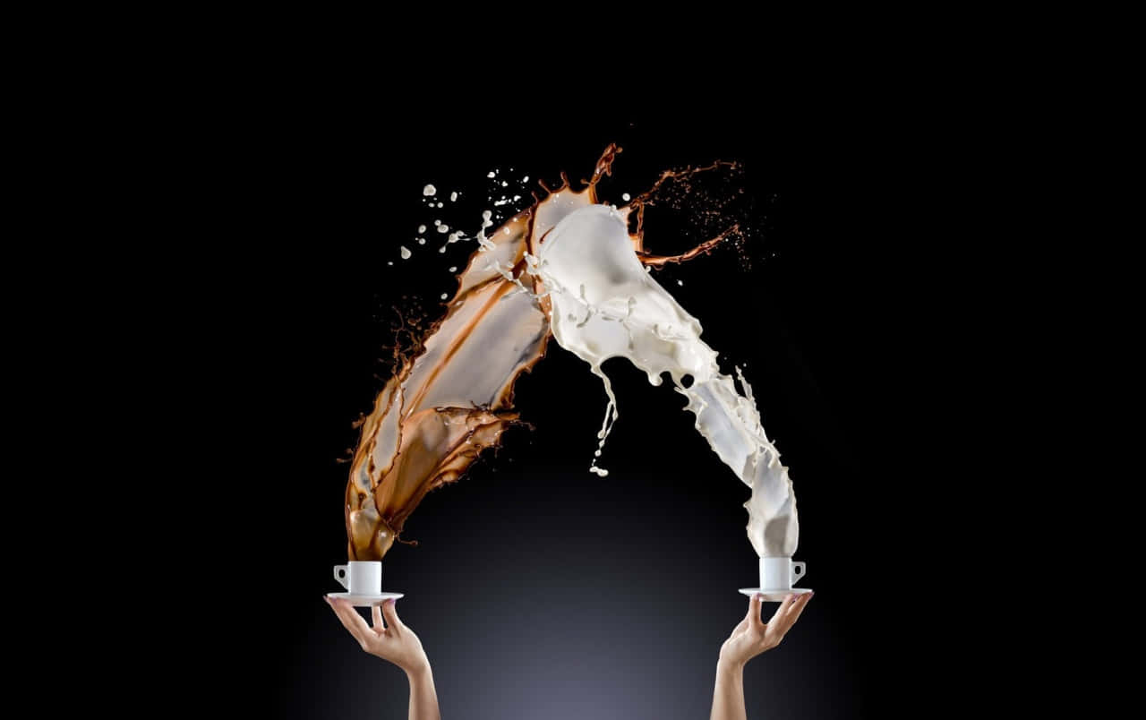 Milk And Coffee 桌布 壁紙 — 兩隻手握住咖啡杯，牛奶和咖啡在黑色背景前戲劇性地在空中飛濺。