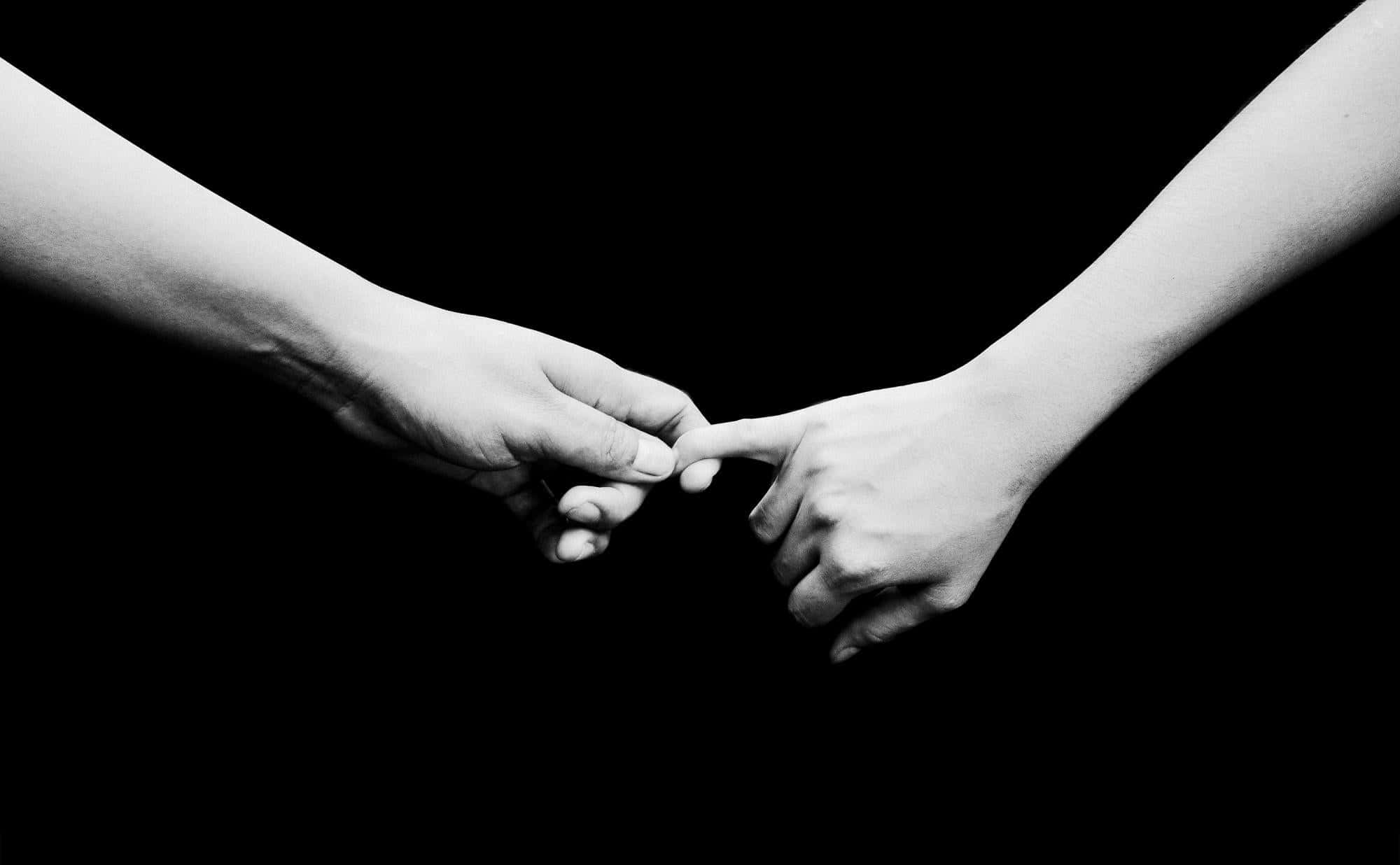 couple love 桌布 壁紙 — 兩隻手穿過黑暗觸碰指尖，呈現強烈的黑白構圖。