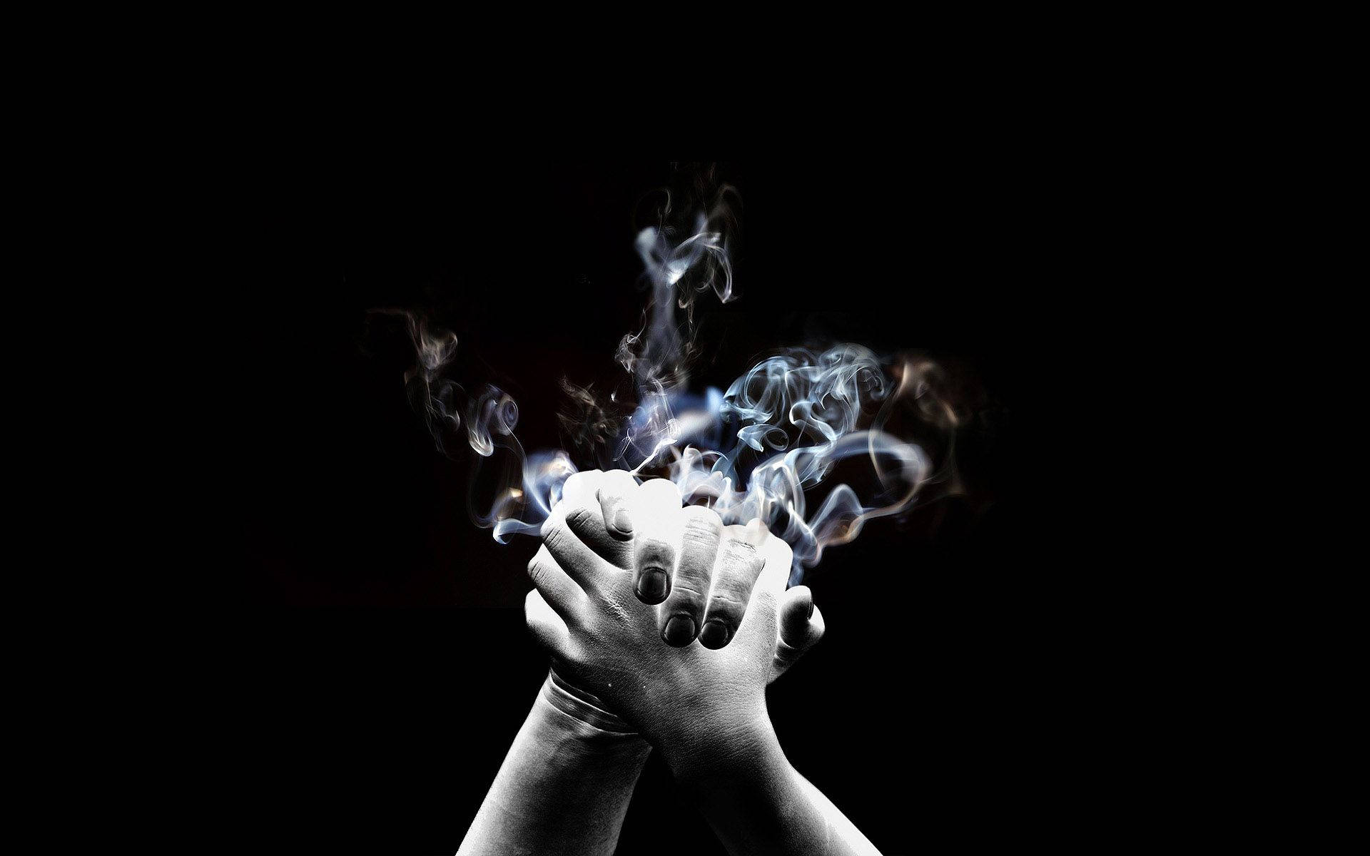 hands 桌布 壁紙 — 兩隻手緊握在一起，在漆黑的背景上散發出旋轉的藍色和白色煙霧。