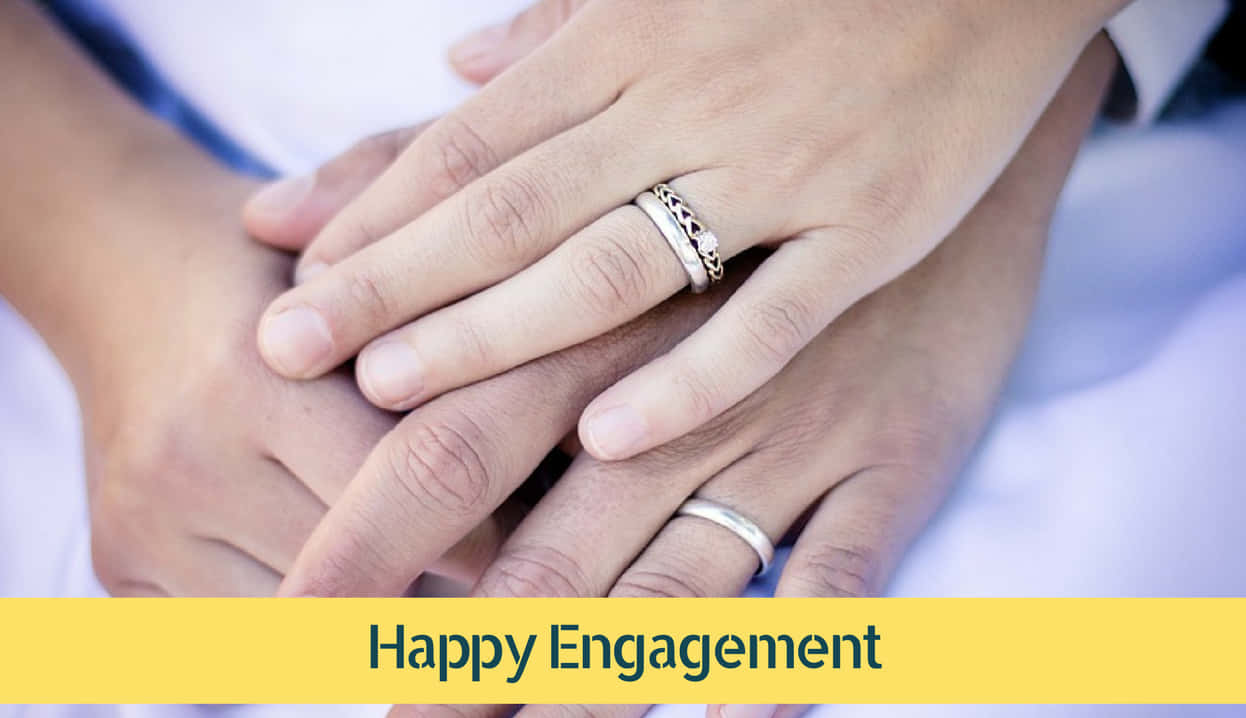 Marriage 桌布 壁紙 — 兩隻手緊握在一起，訂婚戒指在柔和光線下閃耀，背景為模糊的白色。