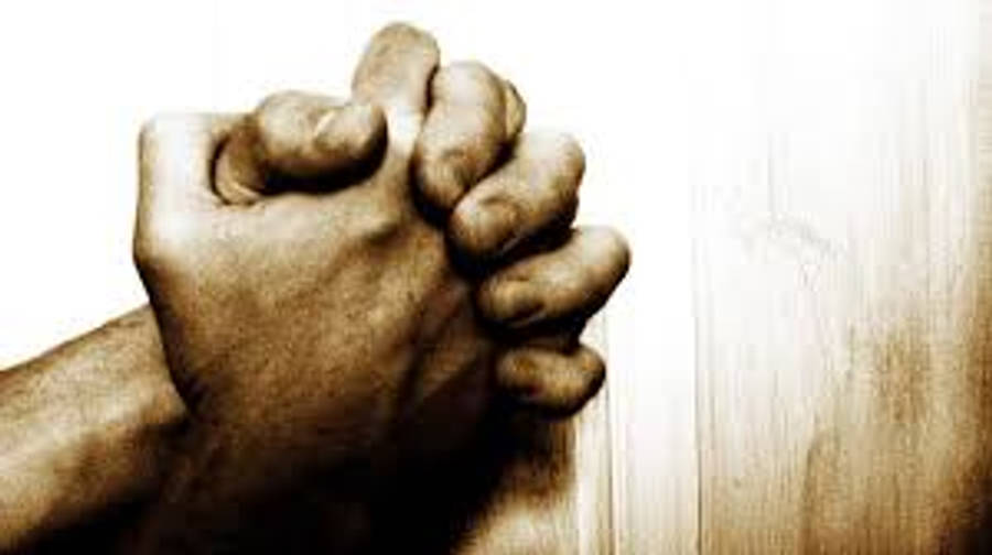 Praying 桌布 壁紙 — 兩隻手緊握祈禱，背景為溫暖棕褐色調的紋理木質表面。