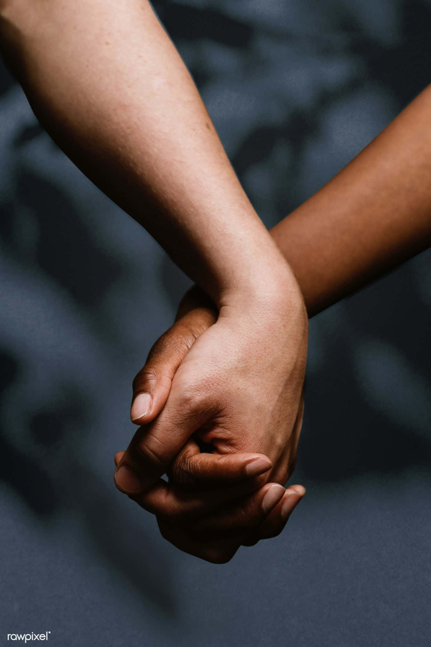 Couple Holding Hand 桌布 壁紙 — 兩隻手緊緊握在一起，背景是模糊的黑暗，傳達深刻的聯繫和支持。