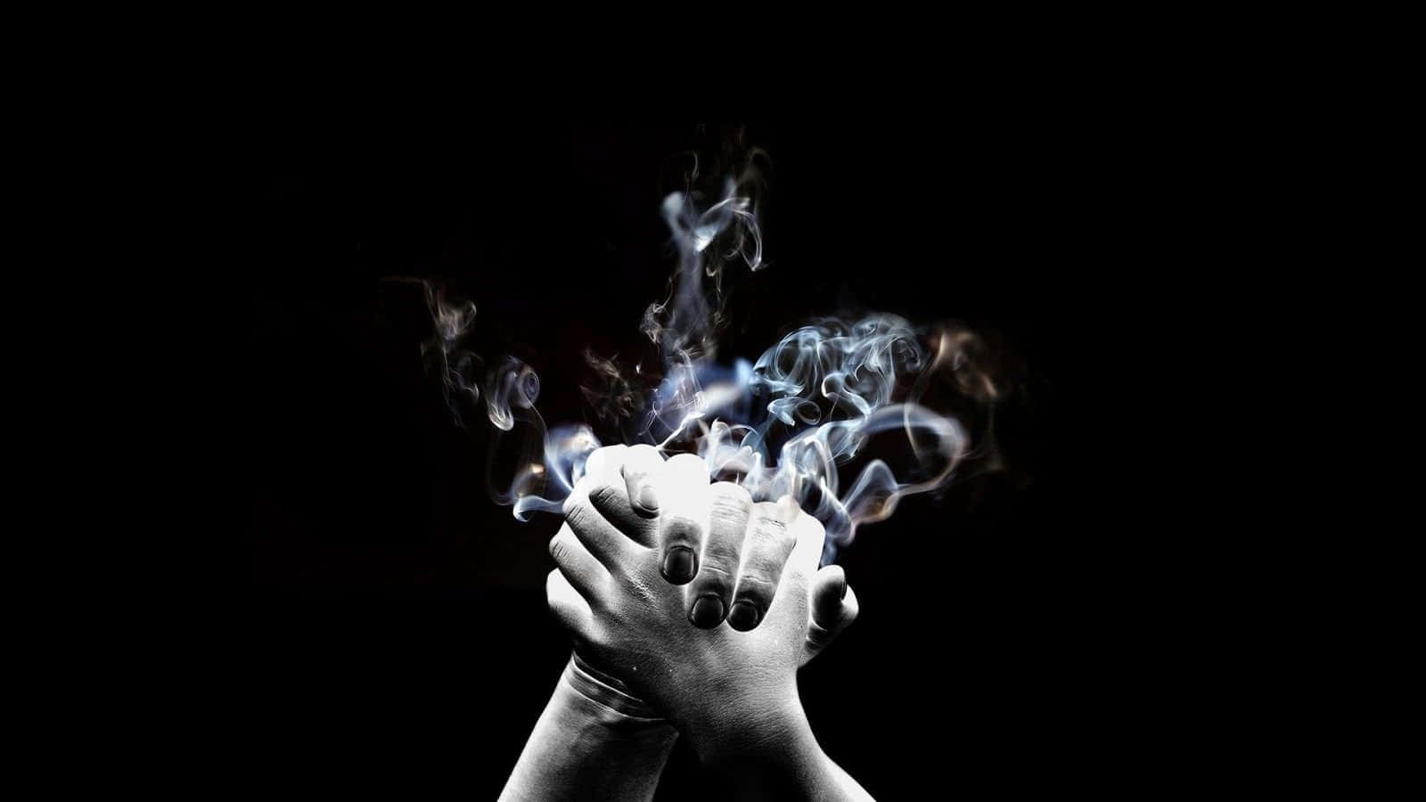 Dark Hand 桌布 壁紙 — 兩隻手緊緊握在一起，黑色背景，之間有旋轉的藍色煙霧升起。