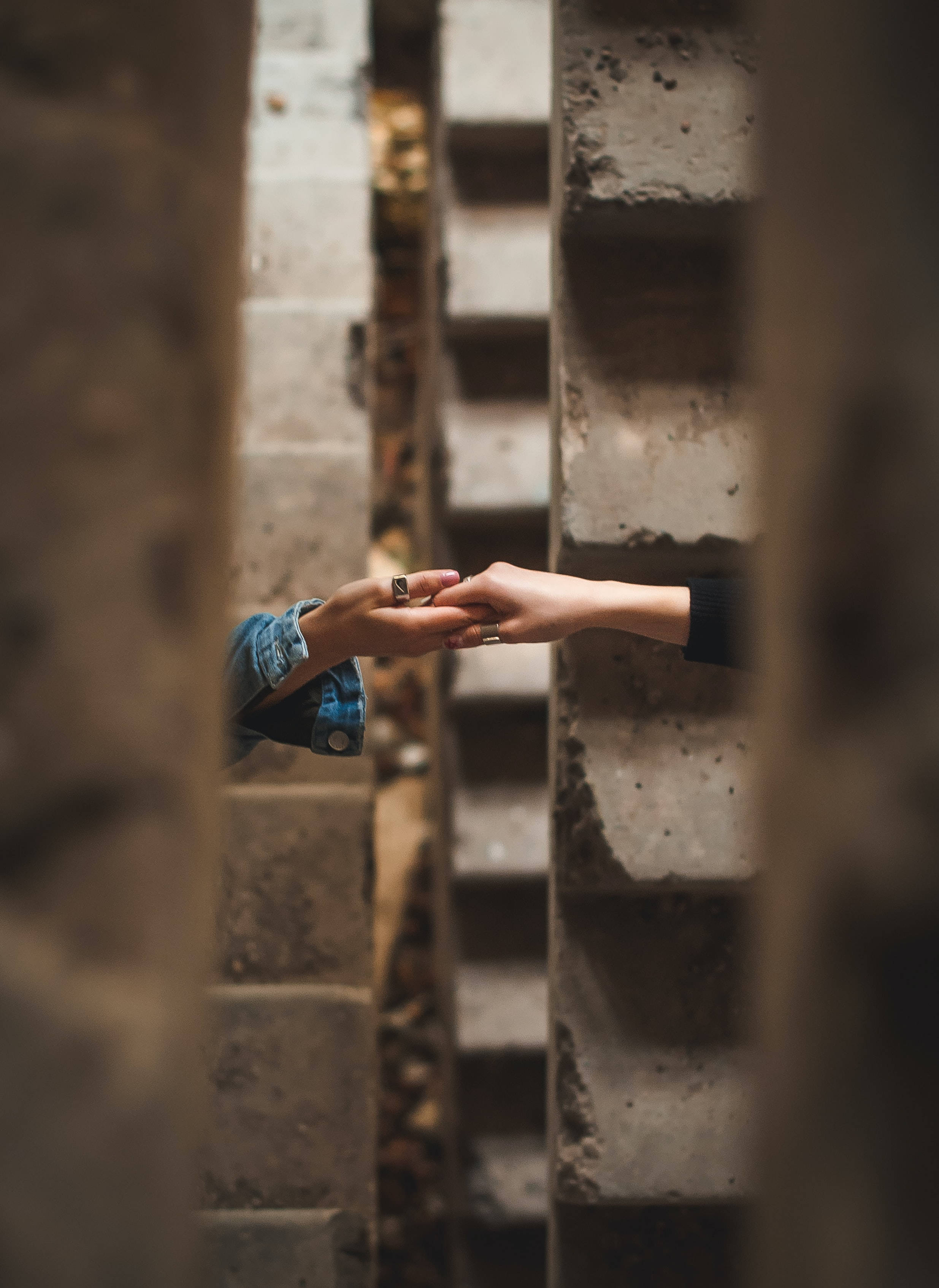 Friendship 桌布 壁紙 — 兩隻手越過風化的石階互相觸碰，在連結的瞬間緊握彼此。