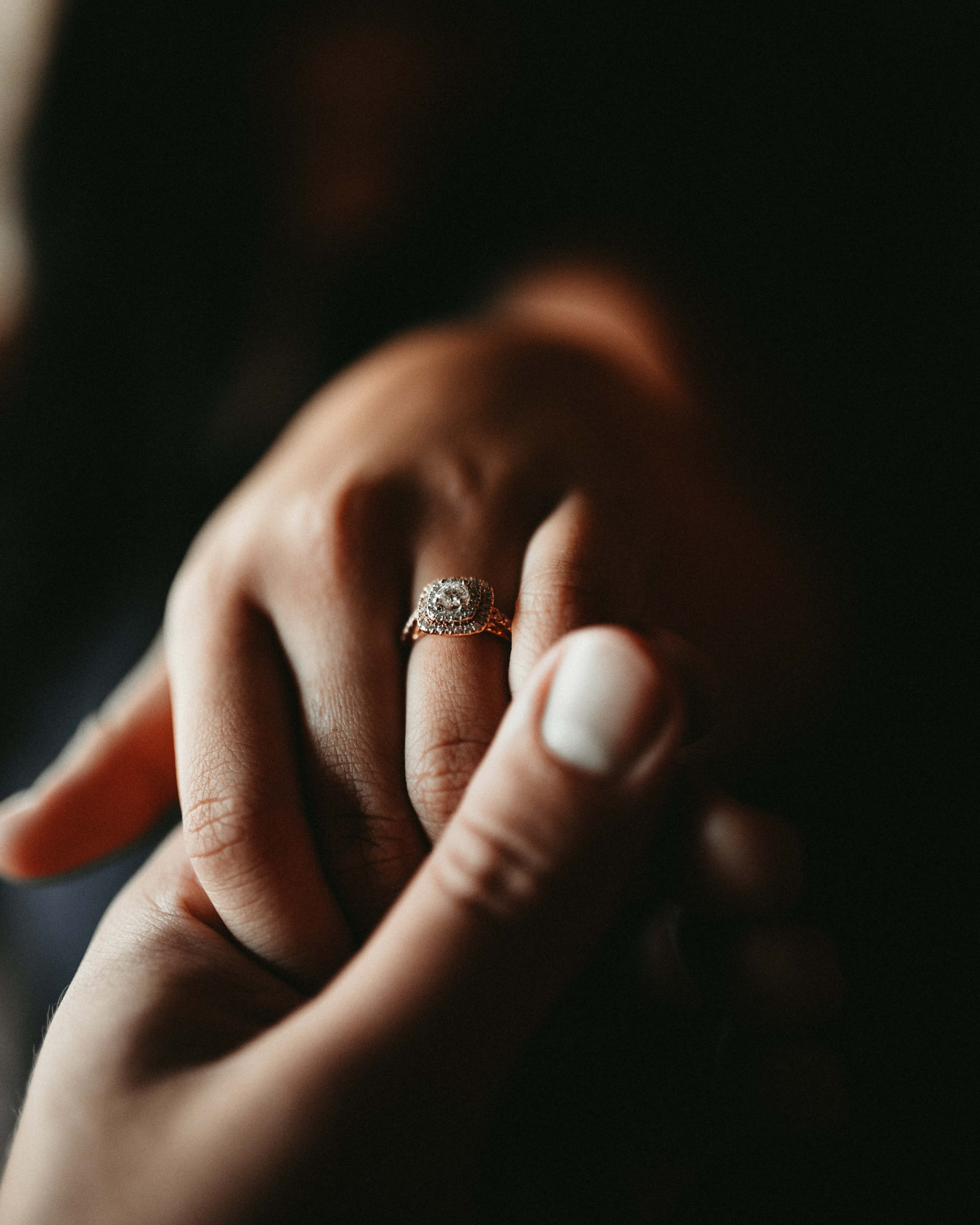 Marriage 桌布 壁紙 — 兩隻手輕輕交握的特寫，無名指上戴著一枚閃閃發光的鑽石訂婚戒指。