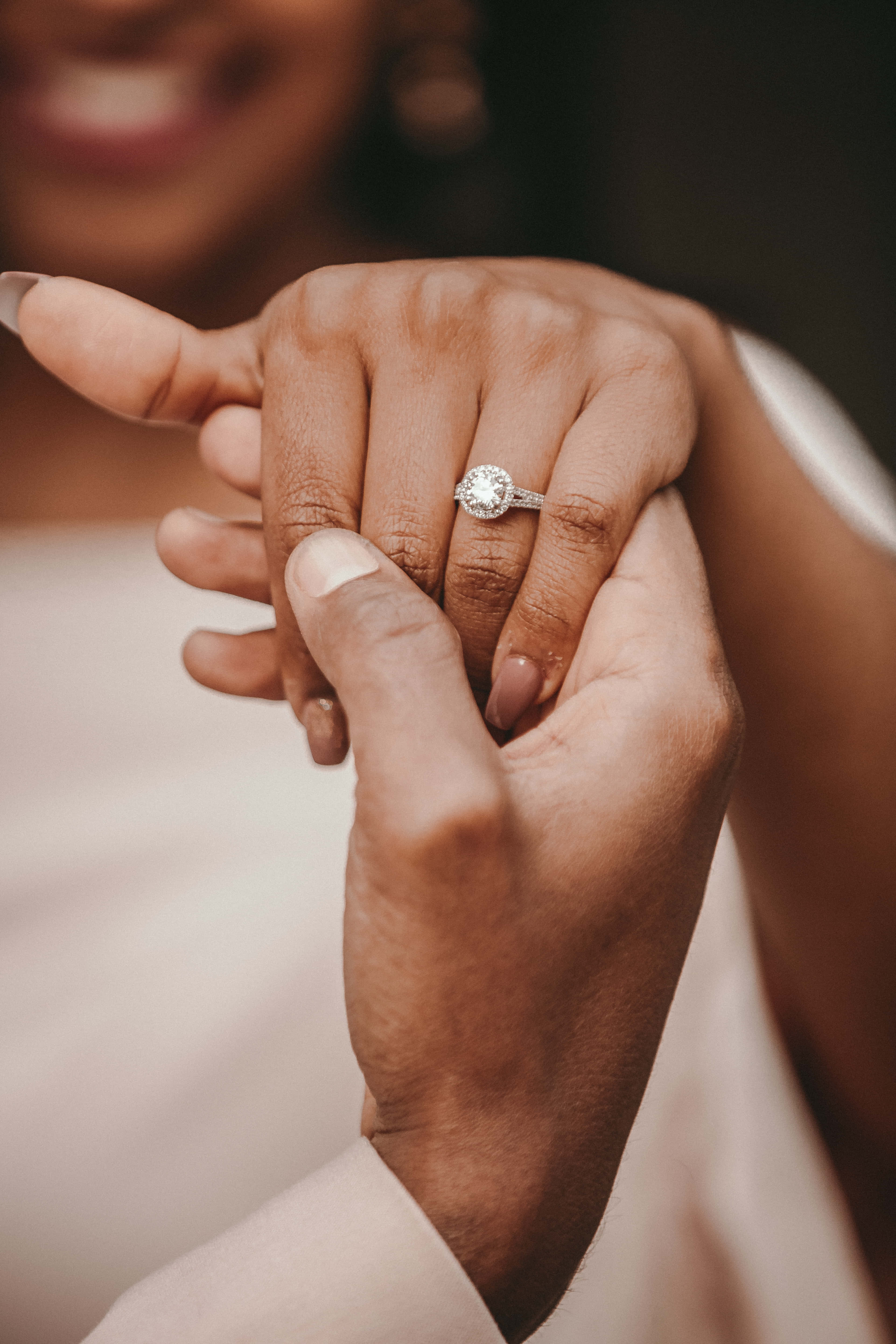 Marriage 桌布 壁紙 — 兩隻手輕輕交握的特寫照片，無名指上戴著閃爍的鑽石訂婚戒指。