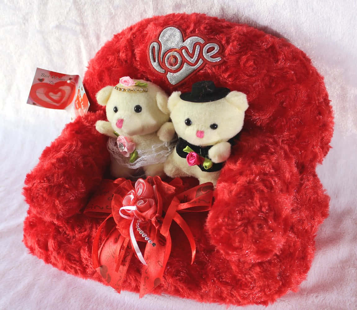 Cute Love 桌布 壁紙 — 兩隻毛絨泰迪熊打扮成新娘和新郎，坐在一張 fluffy 的紅色心形椅子上，上方繡有 'love' 字樣。