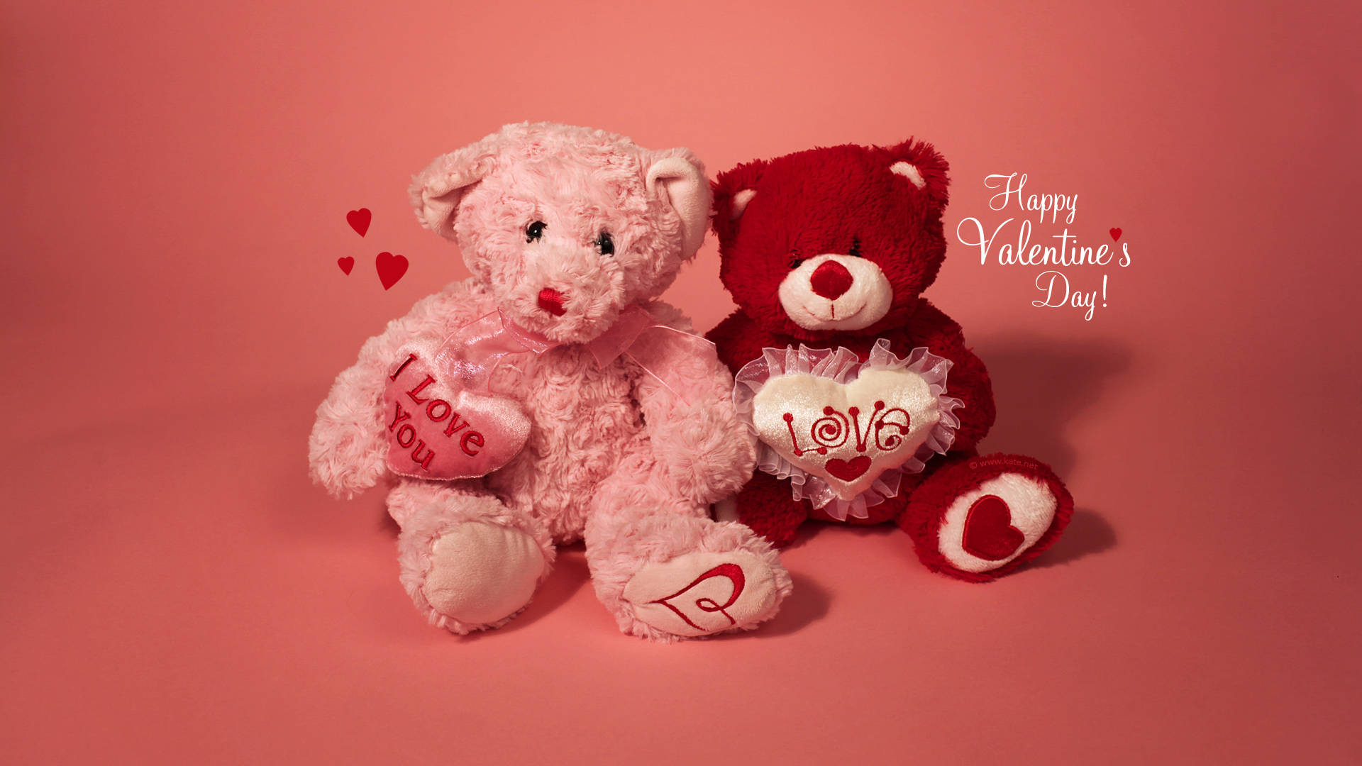 Teddy Bear 桌布 壁紙 — 兩隻毛絨絨的泰迪熊，一粉一紅，拿著寫有「I Love You」和「LOVE」的心形，坐在柔和的粉紅色背景上，背景有漂浮的心形和「Happy Valentine's Day!」文字。