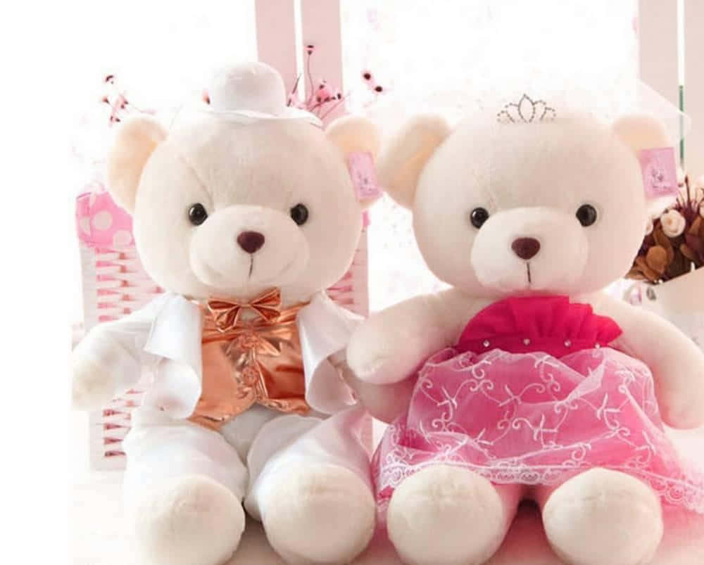 bear love 桌布 壁紙 — 兩隻毛茸茸的白色泰迪熊打扮成新郎和新娘，並排坐在明亮的粉紅色花卉場景中。