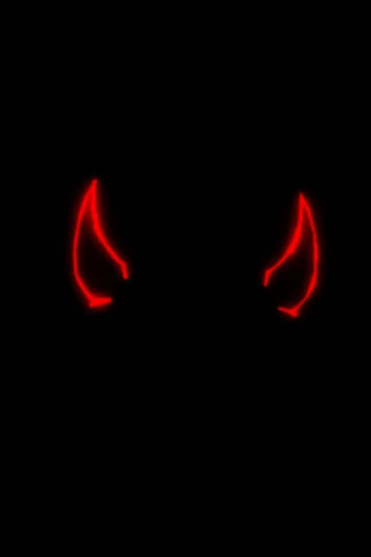 Devil Horns 桌布 壁紙 — 兩隻發光的紅色惡魔角刺穿黑暗，散發著不祥而邪惡的氣息。