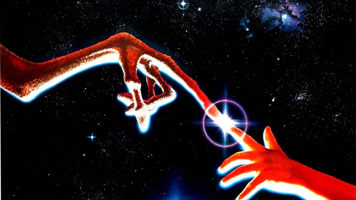Et 桌布 壁紙 — 兩隻發光的紅色手穿過星空，觸碰一個光芒四射的宇宙點。