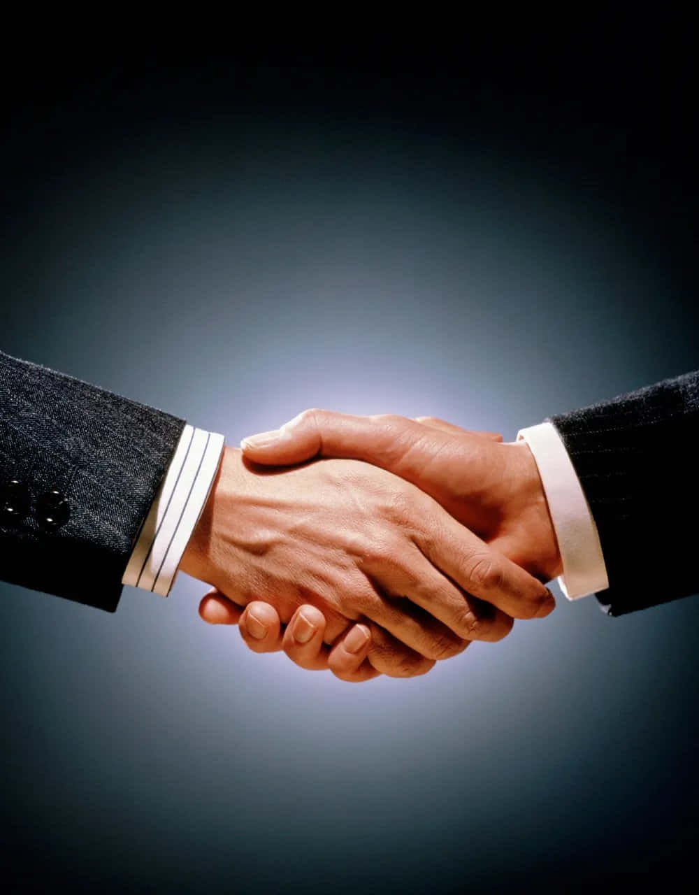 hands 桌布 壁紙 — 兩隻穿著正式西裝的商業手在漸變深藍色背景上緊握。