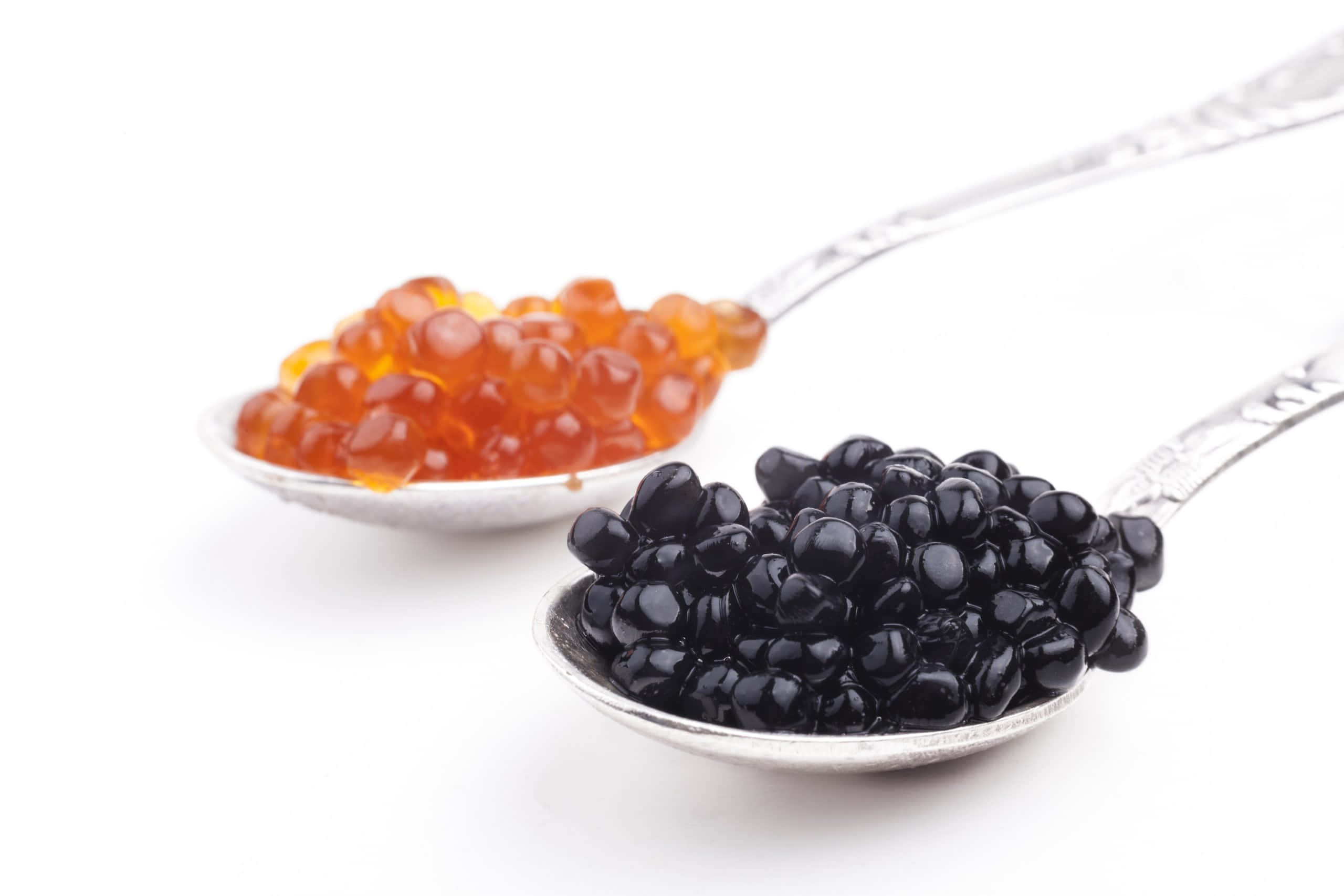 Black Caviar 桌布 壁紙 — 兩隻銀湯匙盛載著鮮豔的橙色和亮黑色魚子醬，襯托在純白背景上。