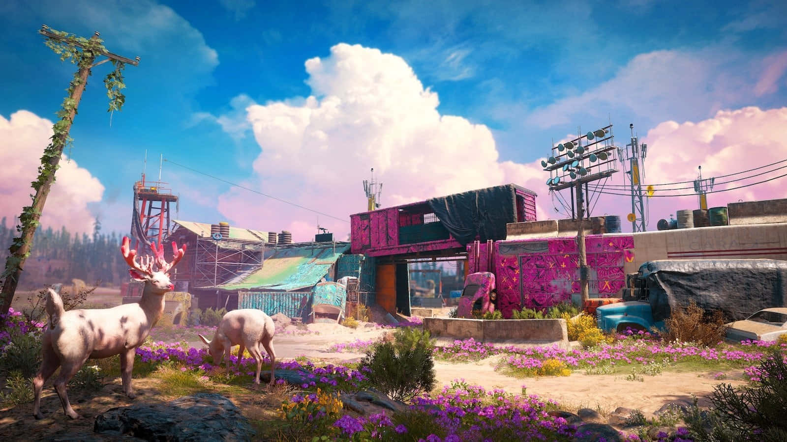 Far Cry New Dawn 桌布 壁紙 — 兩隻鹿在一個充滿活力、被遺棄、佈滿塗鴉的小鎮中，在紫色花朵間吃草，天空湛藍，白雲朵朵。