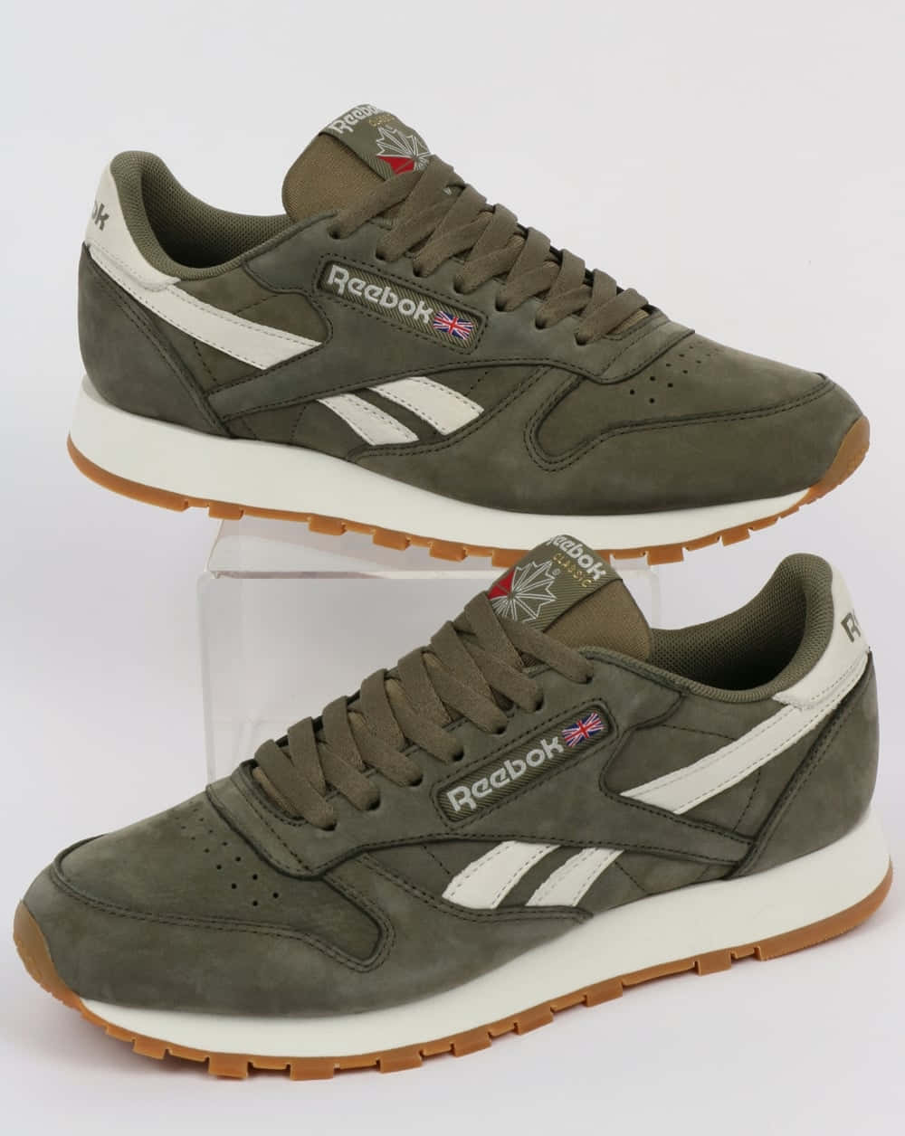 Reebok 桌布 壁紙 — 兩雙橄欖綠色Reebok運動鞋，帶有白色條紋和膠底，展示在透明支架上，背景為純白色。