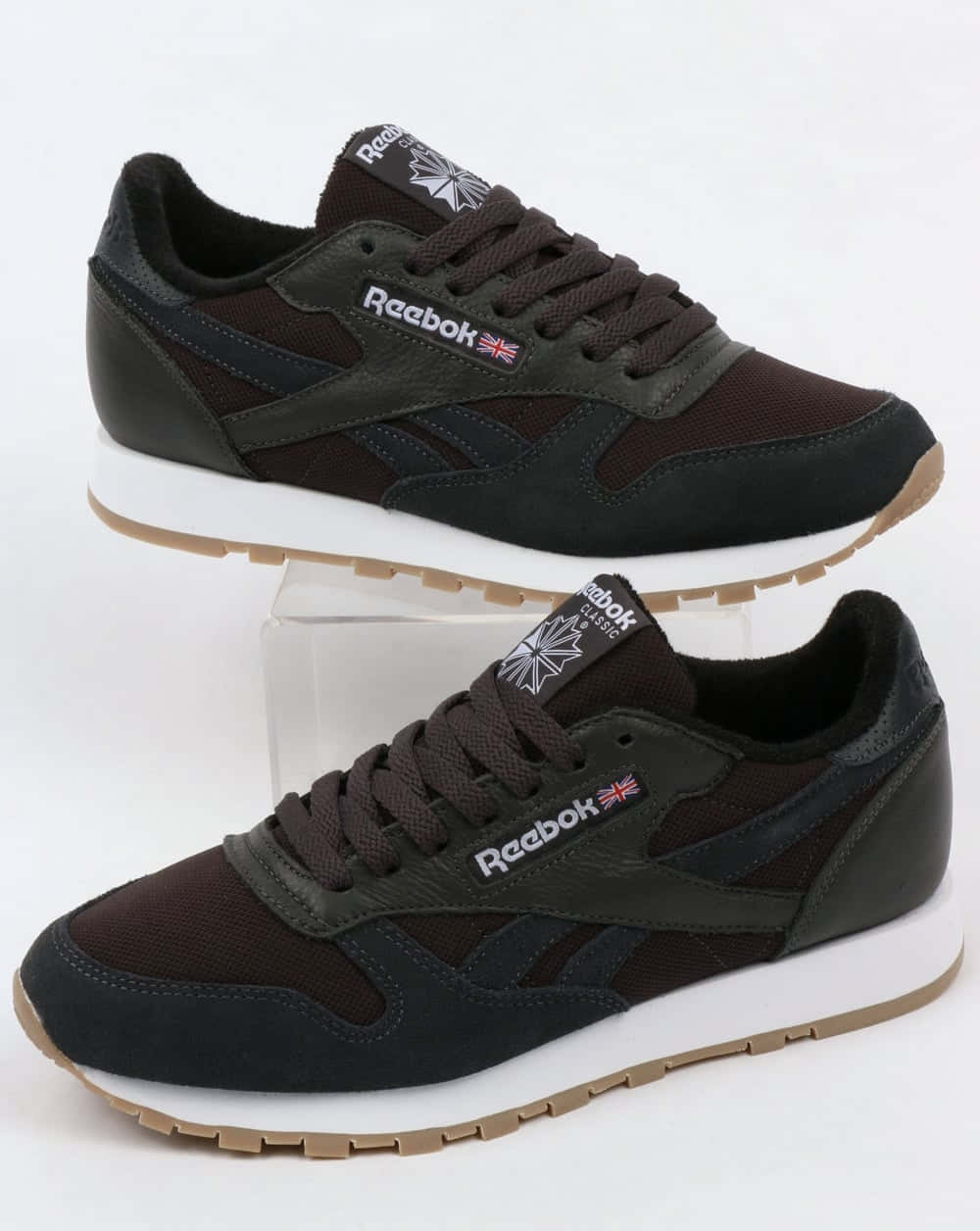Reebok 桌布 壁紙 — 兩雙深棕色 Reebok Classic 運動鞋，白色鞋底，展示在透明支架上，背景為純白色。