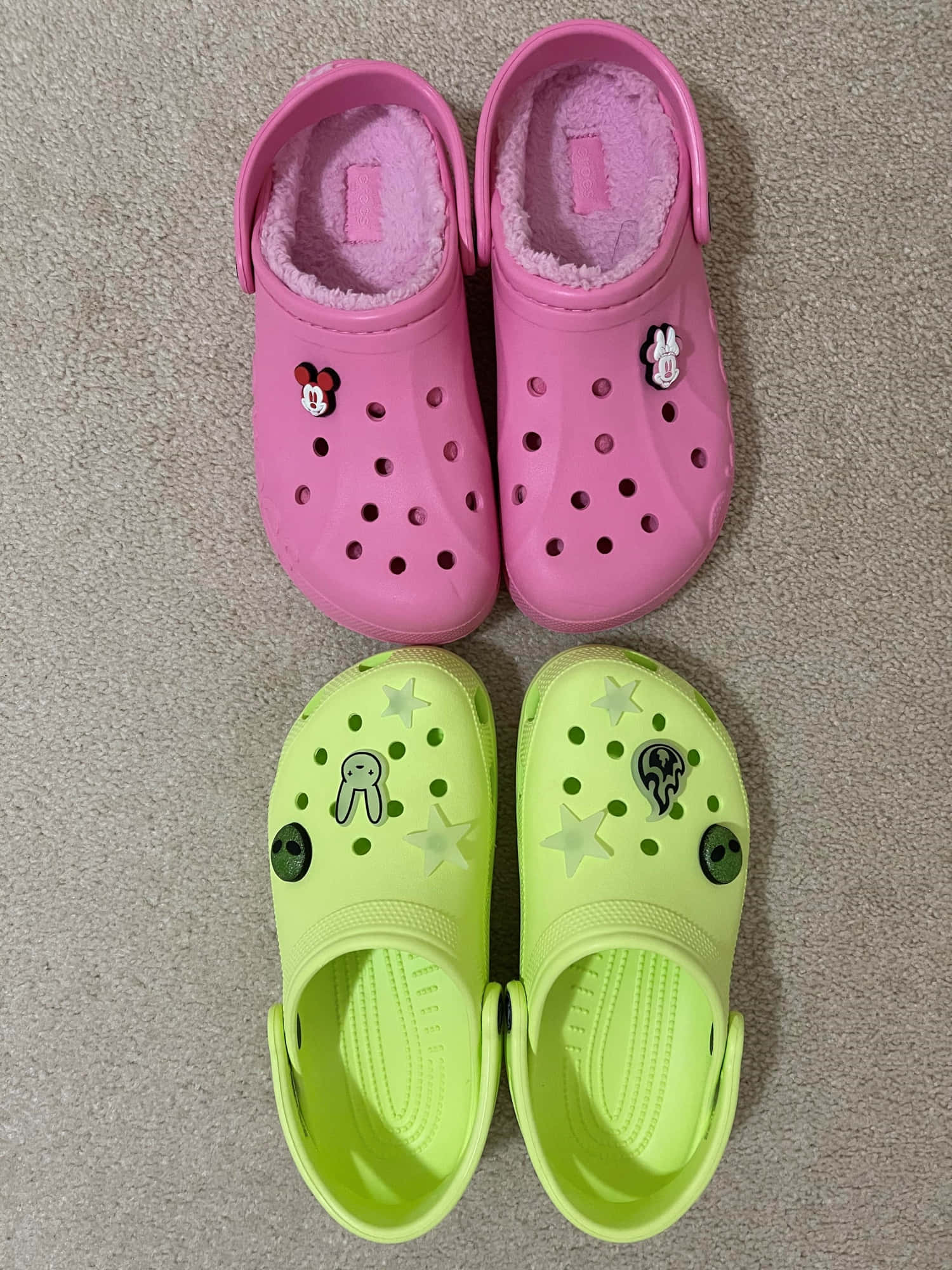 Crocs 桌布 壁紙 — 兩雙色彩繽紛的Crocs鞋，配上可愛角色飾物，整齊地放在米色地毯上。