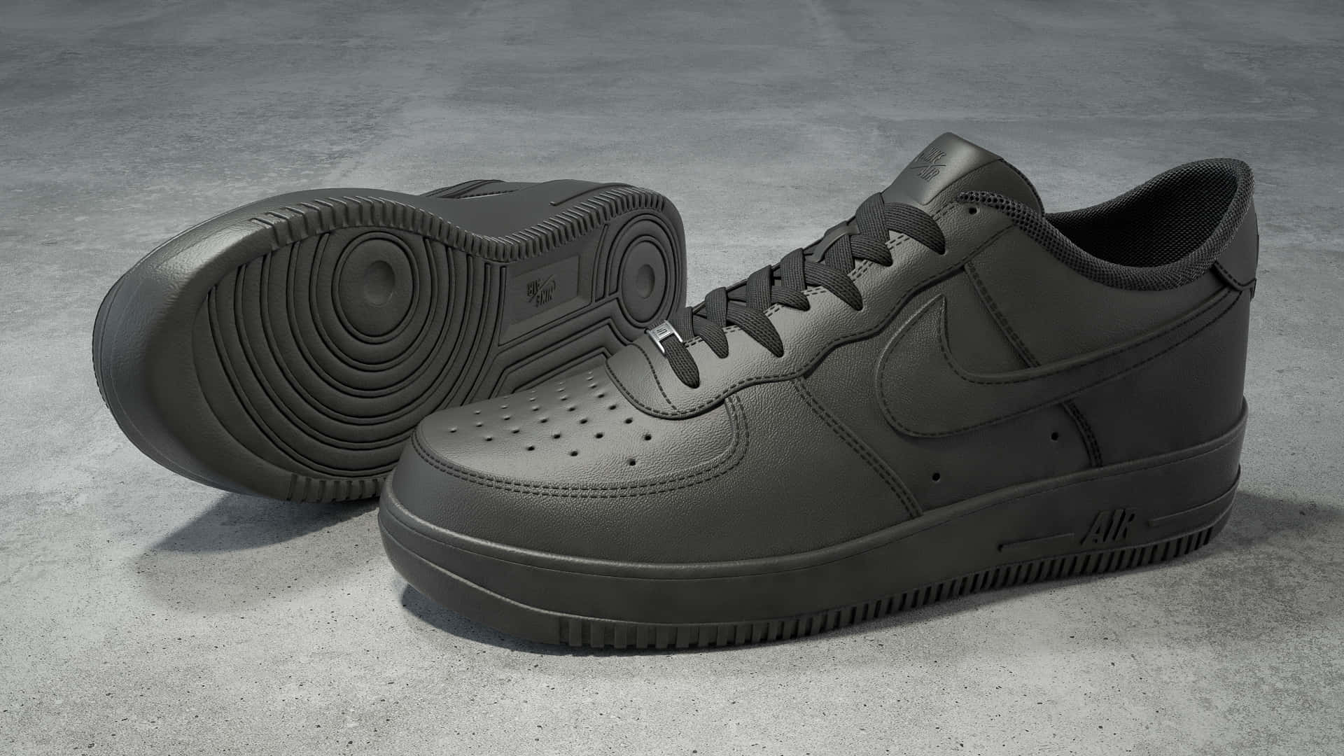 Black Air Force 桌布 壁紙 — 兩雙霧面黑色Nike Air Force 1運動鞋放在灰色混凝土地板上，其中一雙傾斜以展示鞋底細節。
