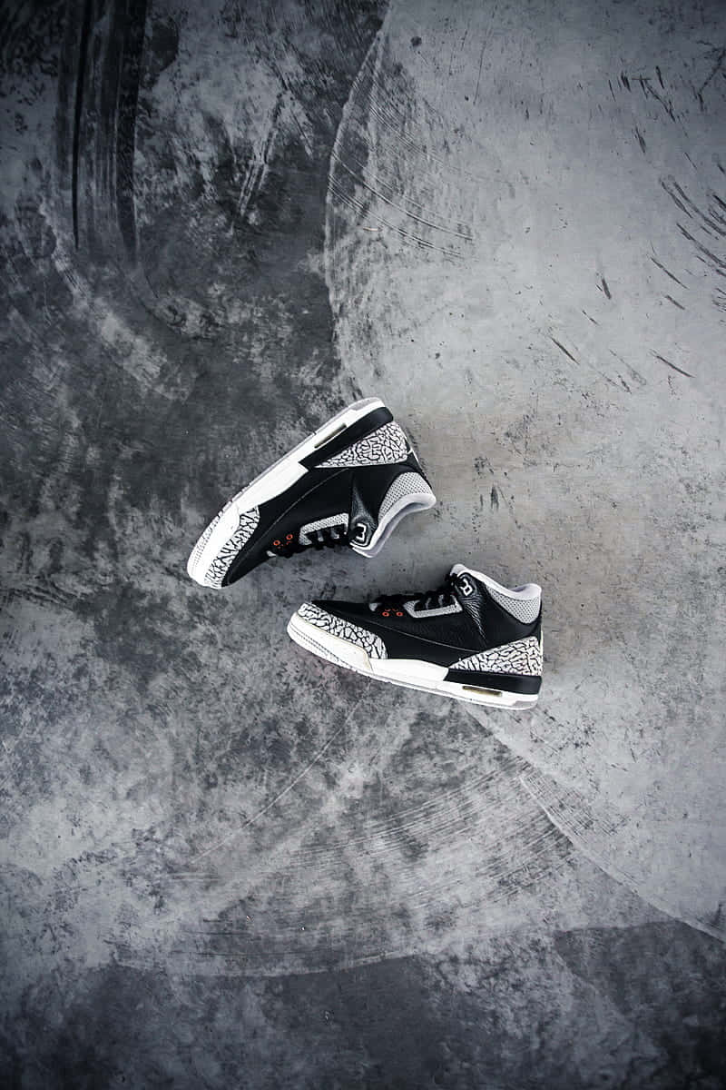 Sneaker 桌布 壁紙 — 兩雙黑白大象印花運動鞋放在帶有輪胎痕跡的紋理灰色混凝土表面上。
